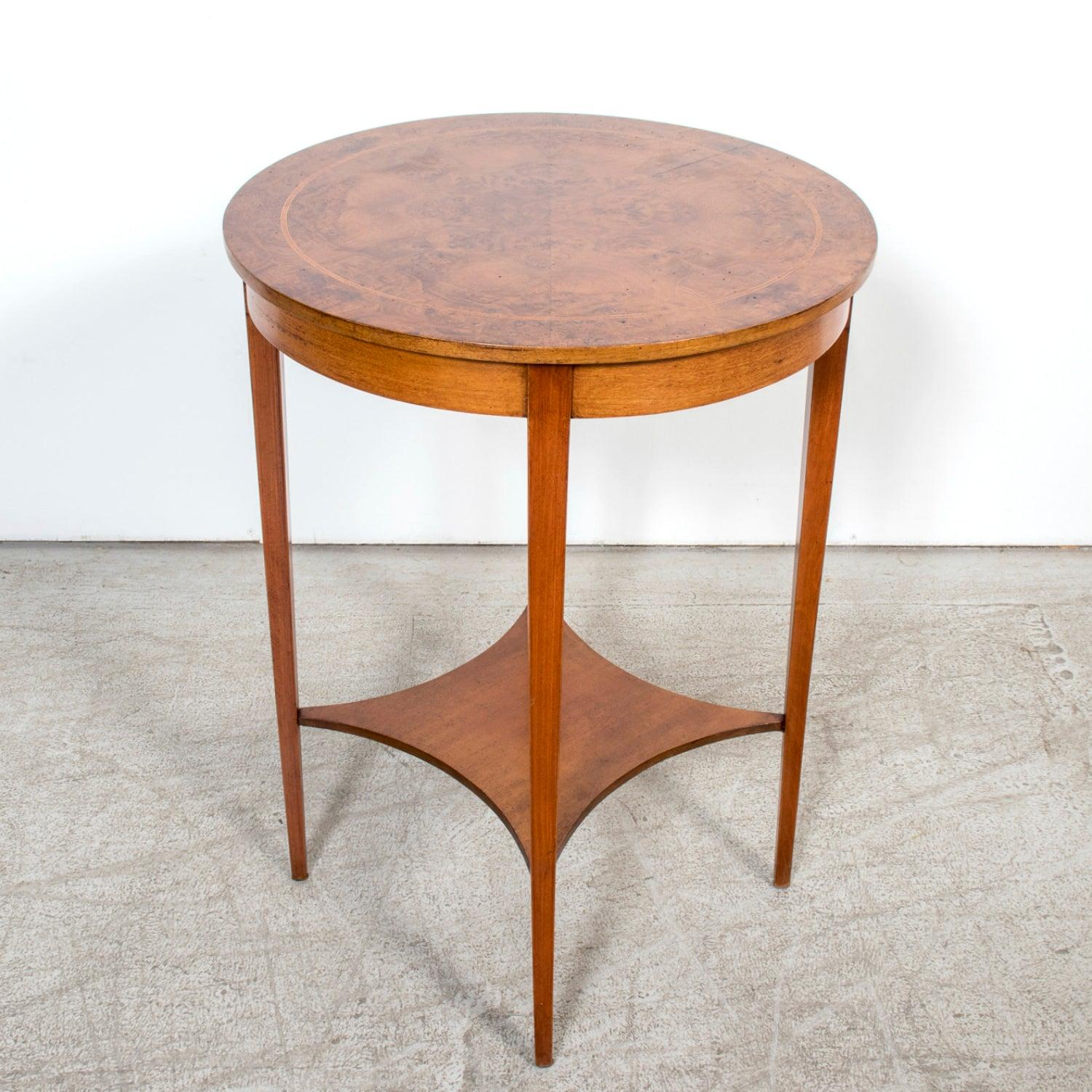 A refined 19th century French Louis XVI style guéridon table handcrafted by talented artisans in Nimes from richly burled walnut. The circular top showcases a beautifully figured walnut veneer with delicate banded inlay, its natural grain forming