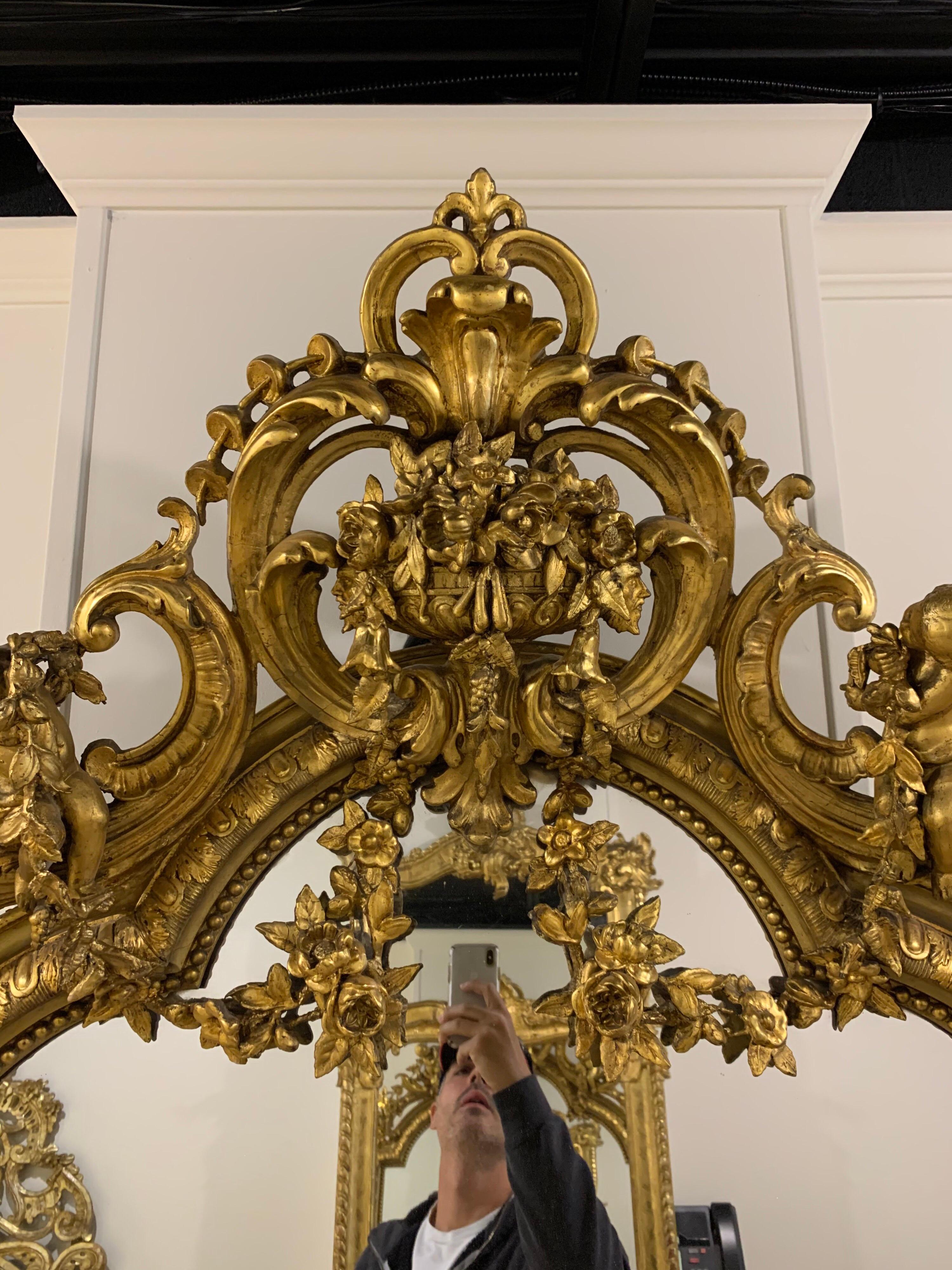 Exceptional 19th century French Louis XVI style carved and giltwood mirror. Amazing floral, images, cherubs and an overflowing urn. Imagine the time and artisanship that went into making this piece. Absolutely stunning! Note: The mirror is cracked