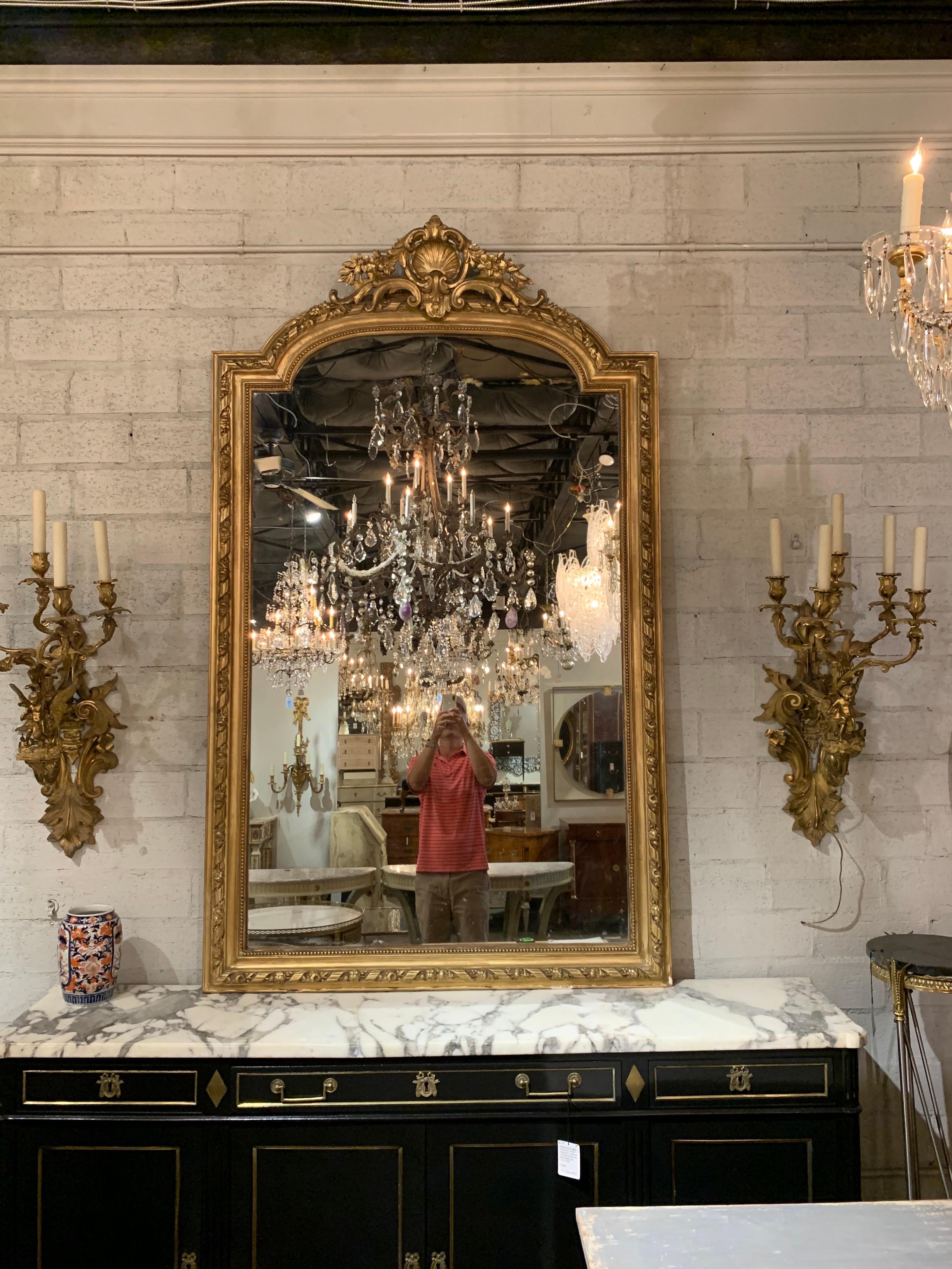 Exceptional large 19th century French Louis XVI style carved and giltwood mirror. Beautiful images of scrolls, floral images and a shell. A very fine piece for an elegant home!