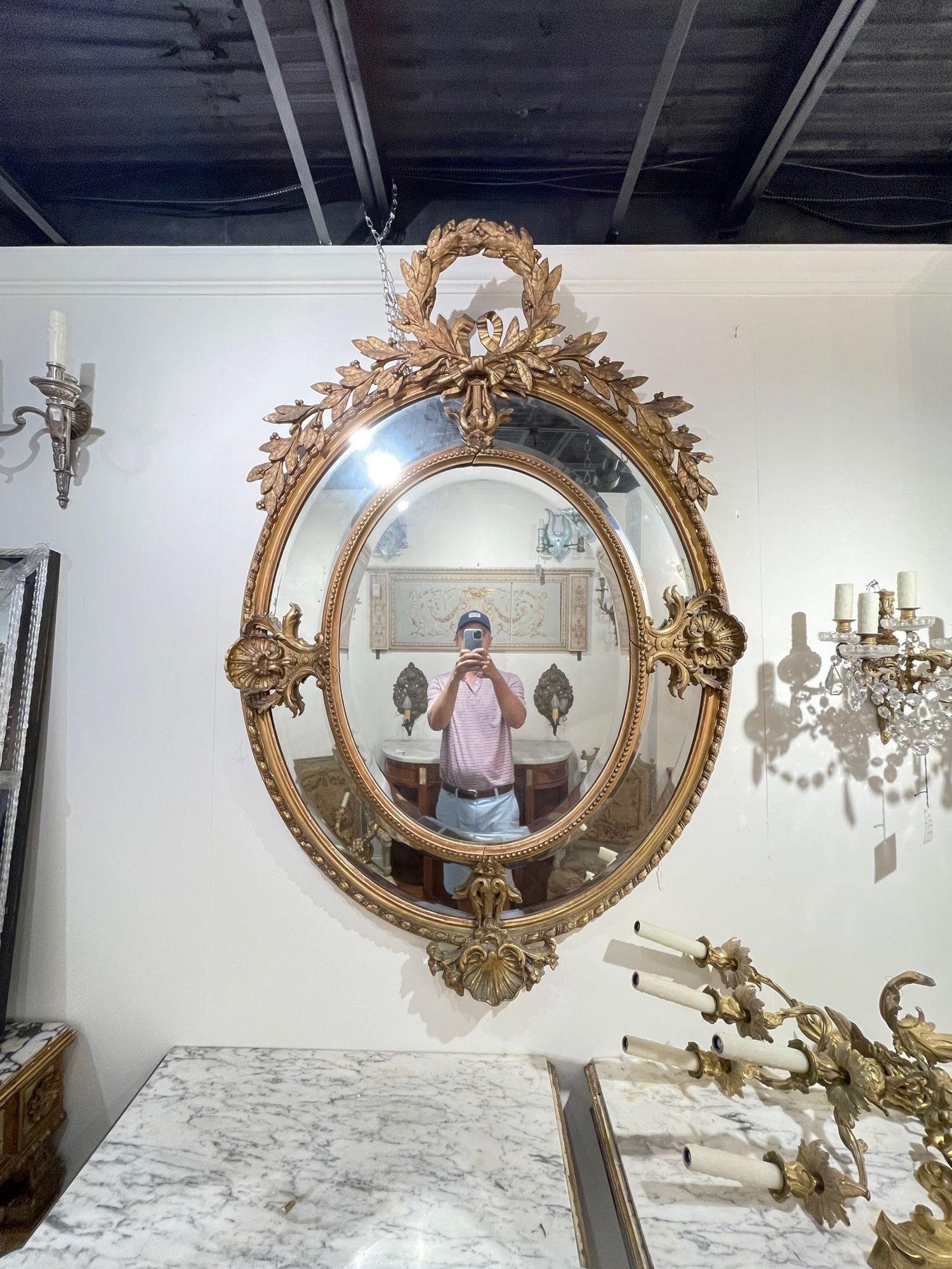 Gorgeous 19th century French Louis XVI style carved and giltwood mirror. This piece has exceptional carvings including an elaborate crest and leaves at the top. Truly special!