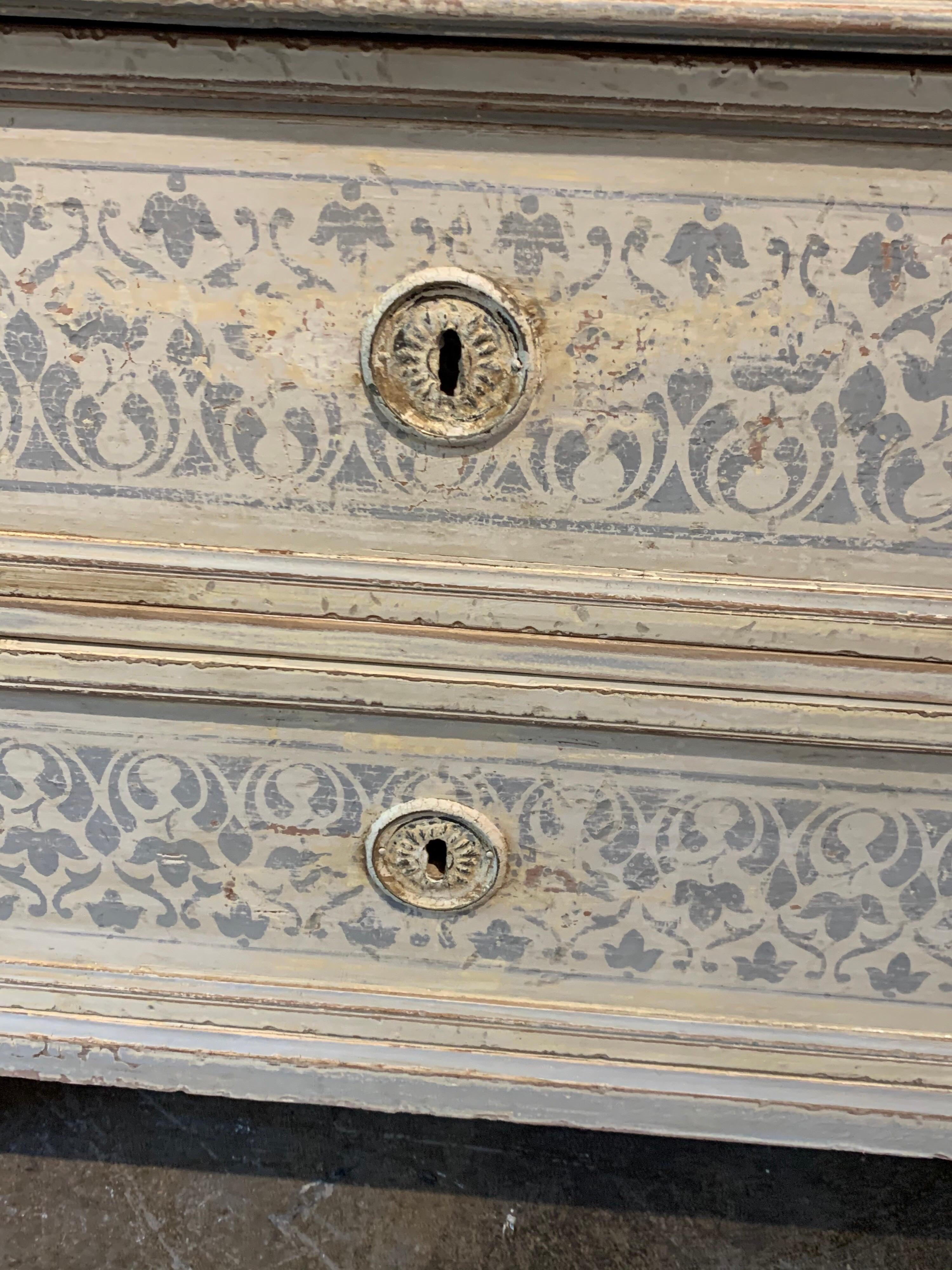 Decorative 19th century French Louis XVI carved and painted commode. Nice floral pattern painted in grey on the drawers and sides of the cabinet. Lovely!