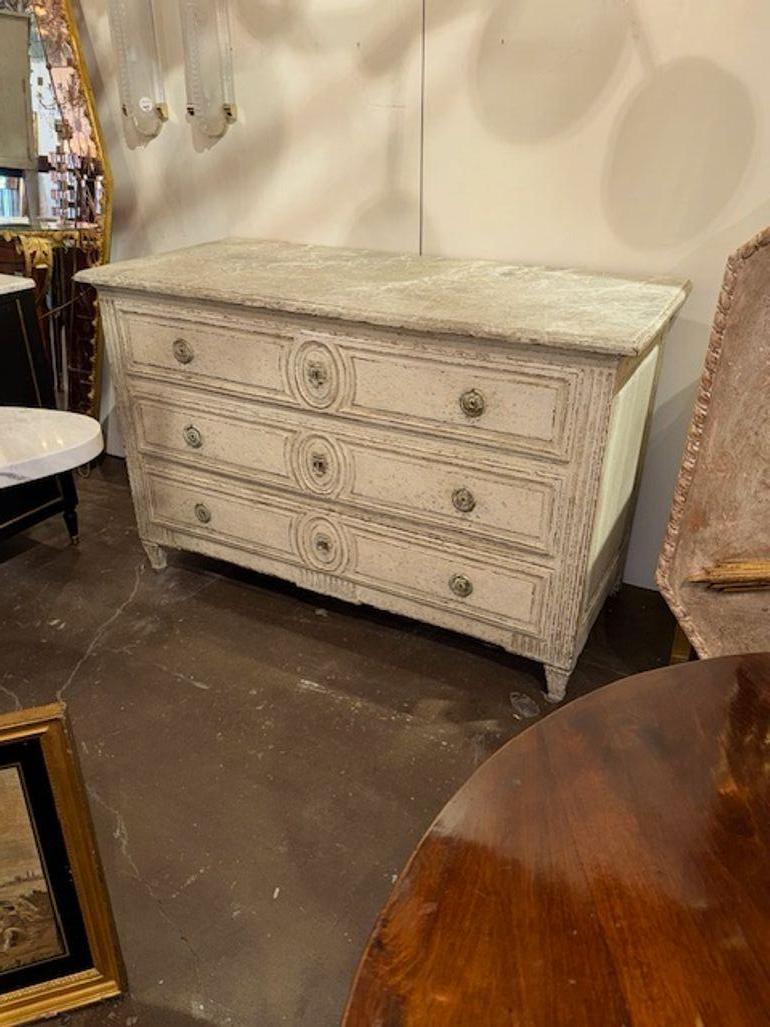 Questa commode in stile Luigi XVI francese del XIX secolo presenta intricati intagli e una finitura dipinta che aggiungono un tocco di antica eleganza a qualsiasi spazio. Il pezzo emana un fascino regale grazie alla sua lavorazione dettagliata e