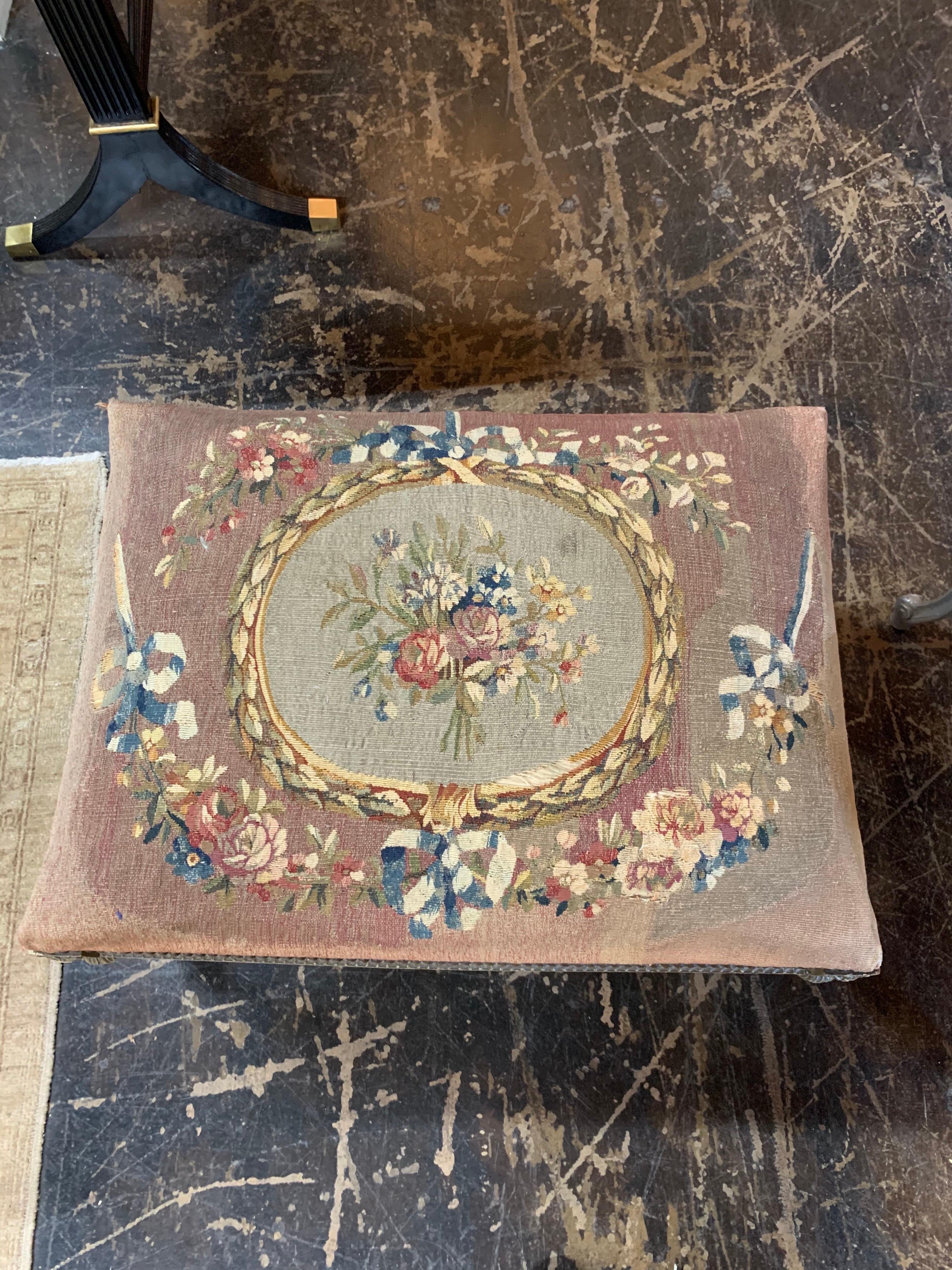 Beautiful 19th century French Louis XVI style carved and painted ottoman. This piece is upholstered in a pretty floral tapestry. A true classic!