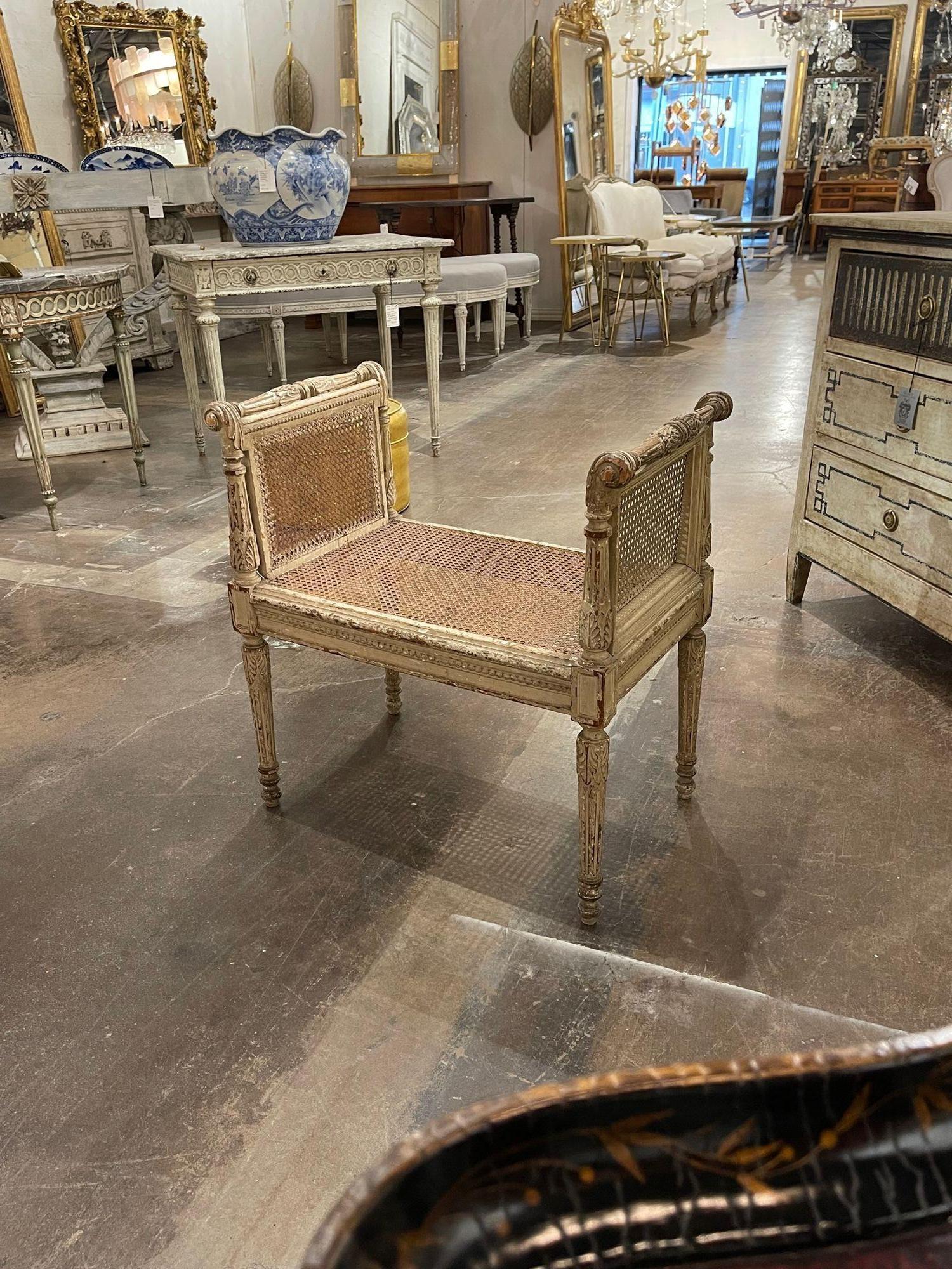 Beautiful 19th century French Louis XVI style carved and painted vanity stool. Featuring nice carvings, a beautiful patina and a caned sides and seat. A classic look that adds a real touch of charm!