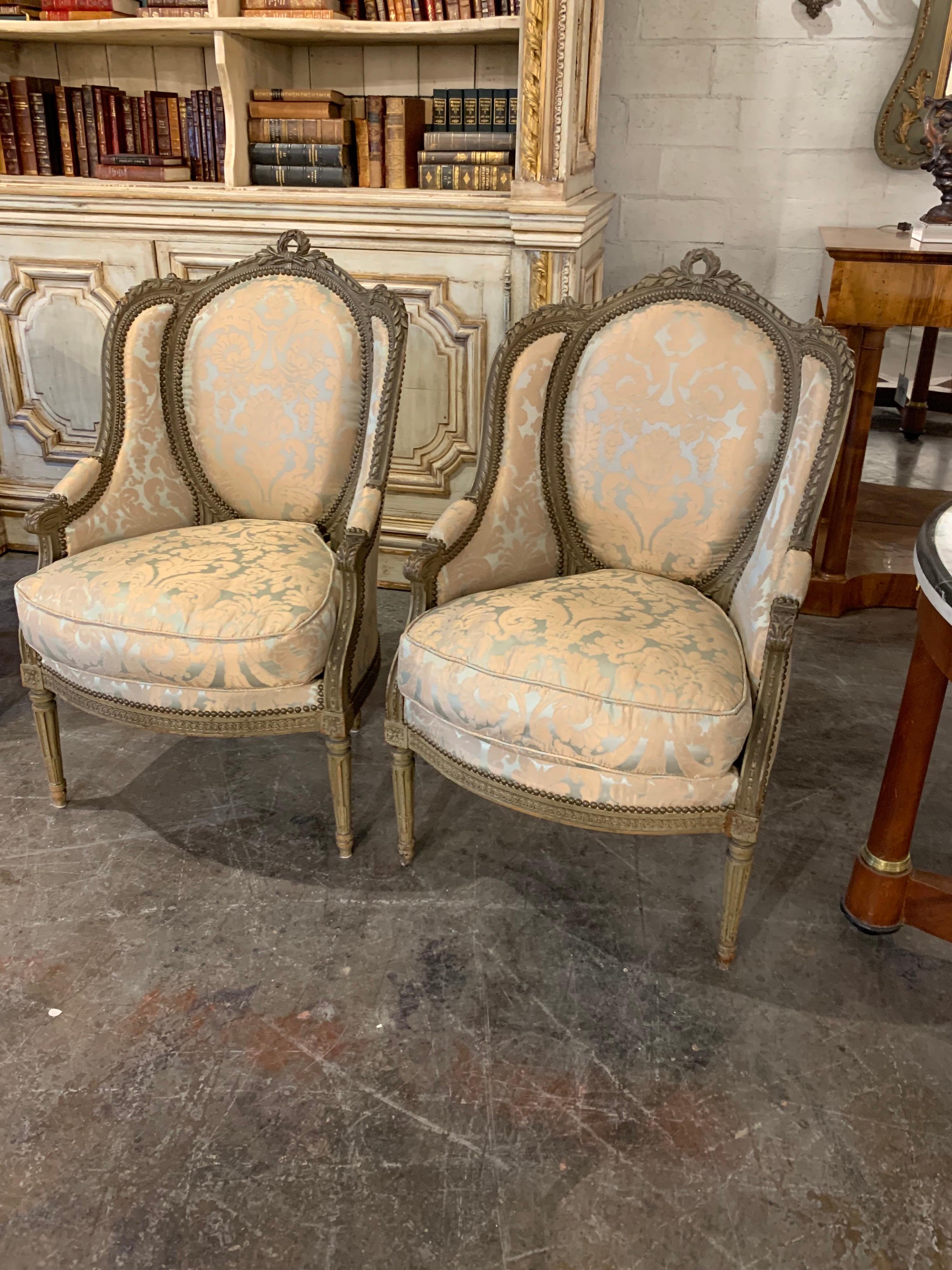 Exquisite pair of 19th century French Louis XVI style carved bergeres. Upholstered in a beautiful silk fabric and very Fine carvings on these! A true Classic! Note: Price listed is per item.