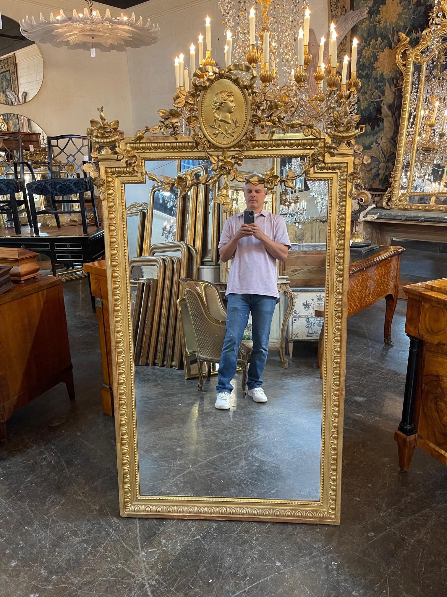 Beautiful 19th century Louis XVI carved giltwood mirror. Featuring very fine Neo Classical carved designs including bows, flowers and a human face. A true work of art!