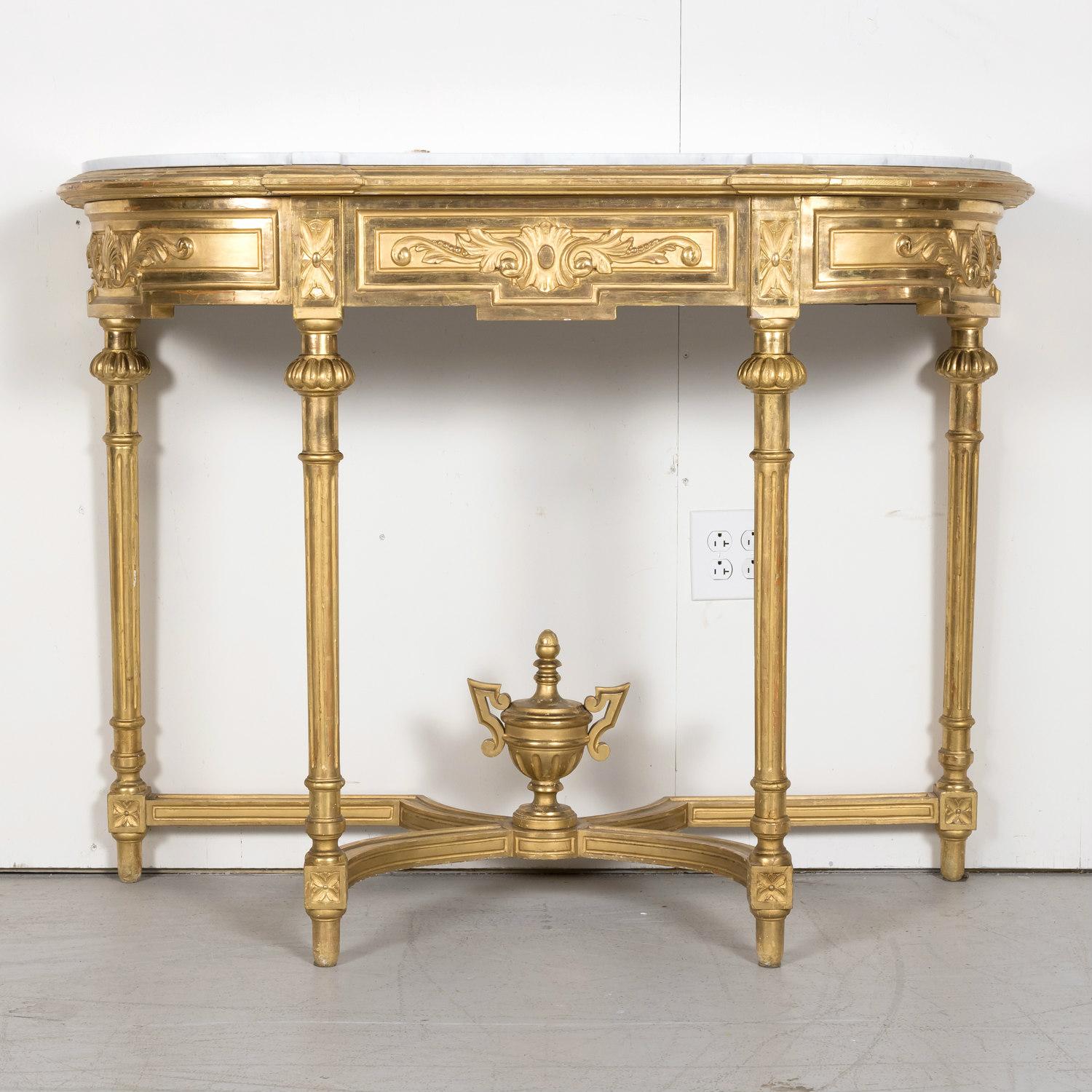 A striking 19th century French Louis XVI style carved giltwood wall console having the original shaped Carrara marble top above a giltwood frame, circa 1880s. This lovely neoclassical console features a shaped and beautifully carved frieze with