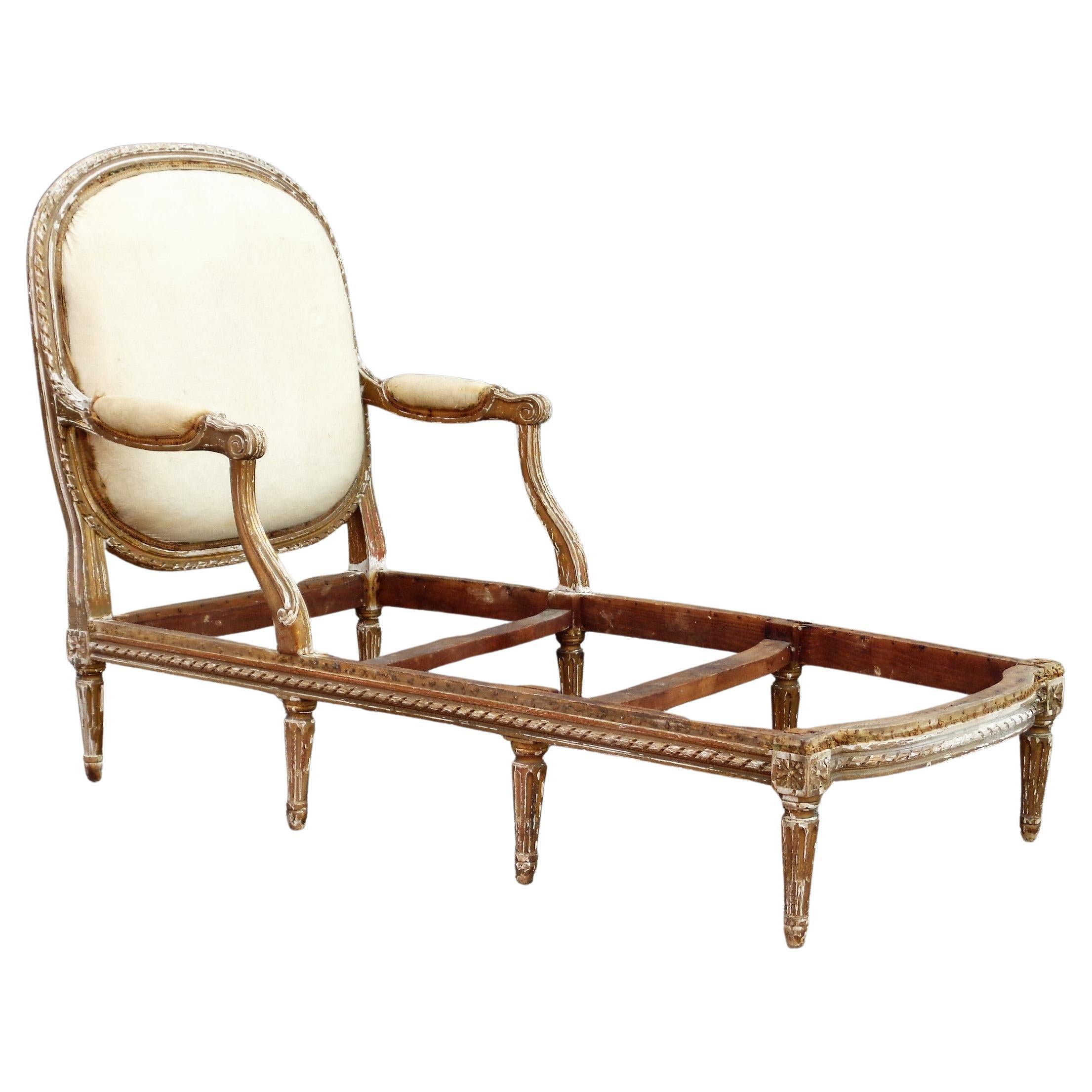 19th century French Louis XVI style chaise lounge w/ a beautiful sculptural form. Nicely detailed carving. Distressed old worn dull gilded surface, underlying gesso, bare wood. Chaise has been deconstructed down to the original old muslin w/ trim on