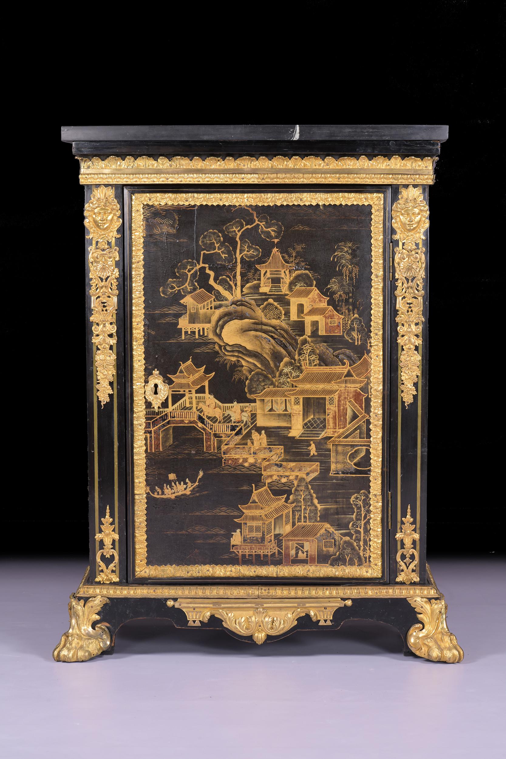 A very fine French ormolu-mounted chinoserie black and gold lacquer pewter-inlaid ebony side cabinet of very neat proportions, with a rectangular black marble top above a decorated ormolu frieze, above a chinoserie lacquered panel decorated with a