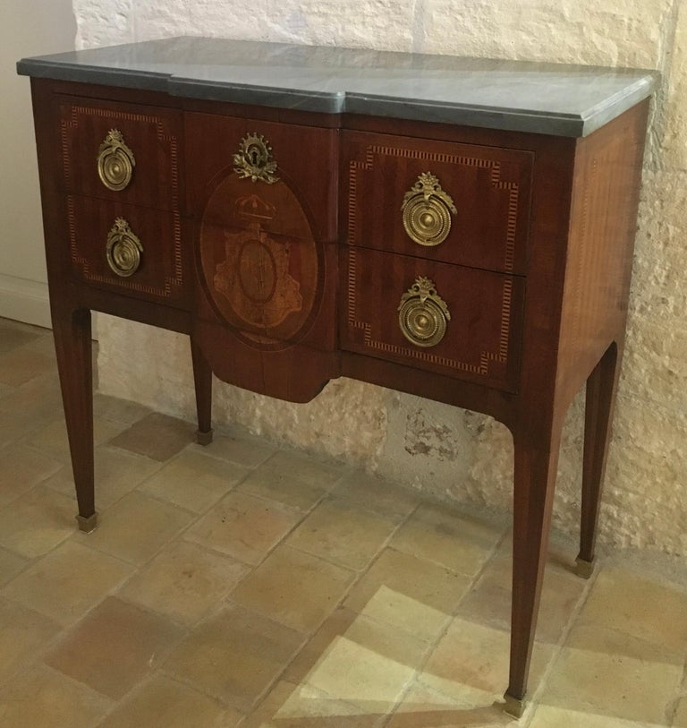 Elegant and perfectly sized 19th century French Louis XVI style commode or dresser. This mahogany two-drawer commode has gilt bronze hardware and mounts, inlaid on all sides, and a beautiful grey marble top. A sophisticated piece with Classic lines
