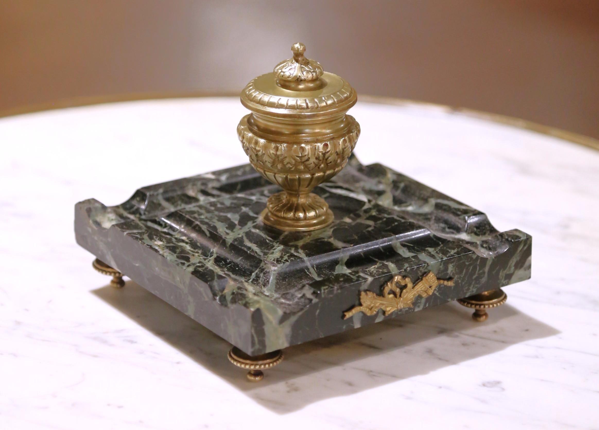 Realizzato in Francia intorno al 1880, questo elegante calamaio da tavolo è un raffinato esempio di design in stile Luigi XVI. La base quadrata è realizzata in marmo verde scuro riccamente venato con bordi modanati e poggia su quattro piedi a toupie