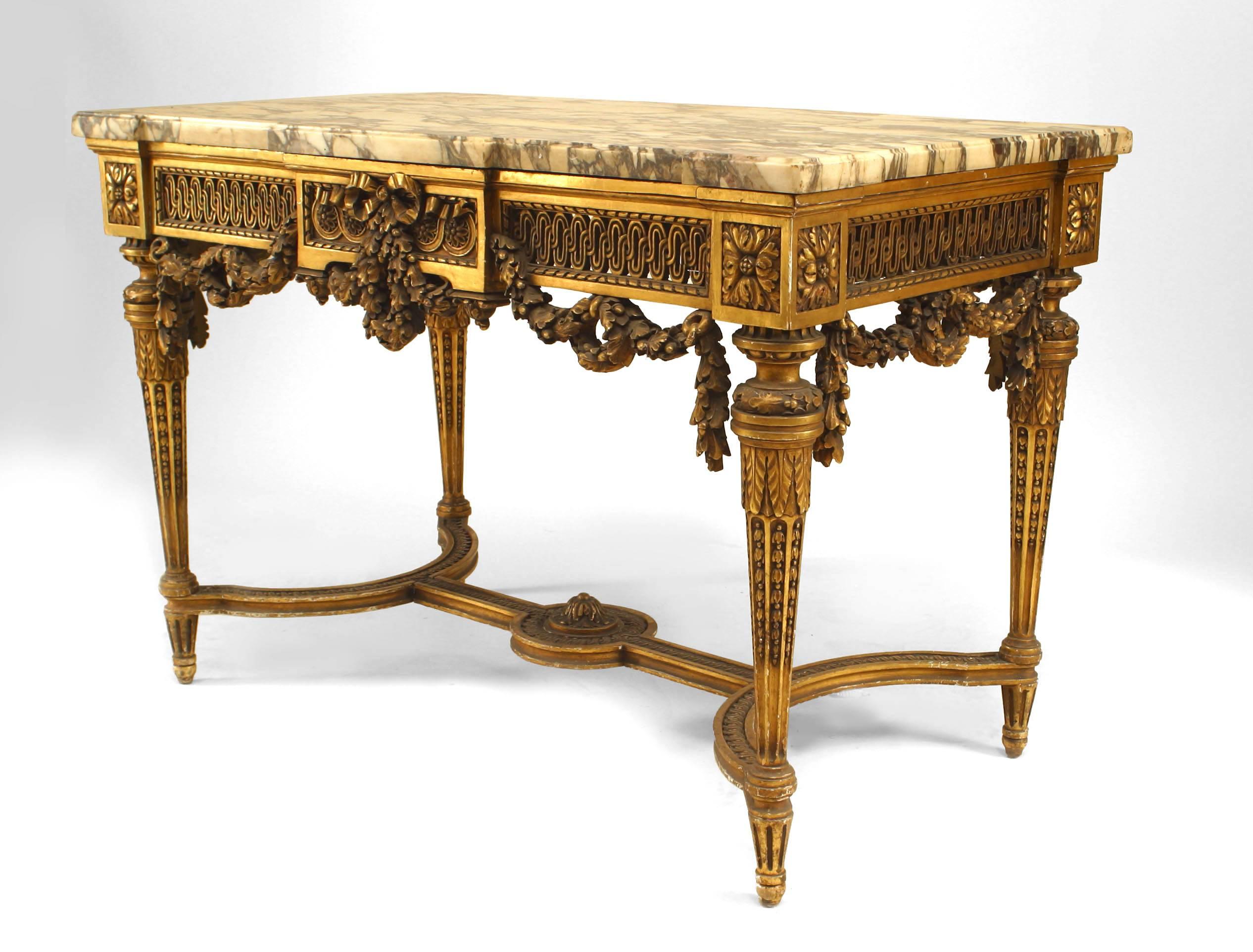 French Louis XVI style (19th Century) gilt center table with stretcher, marble top, and open filigree apron with swag carving.
