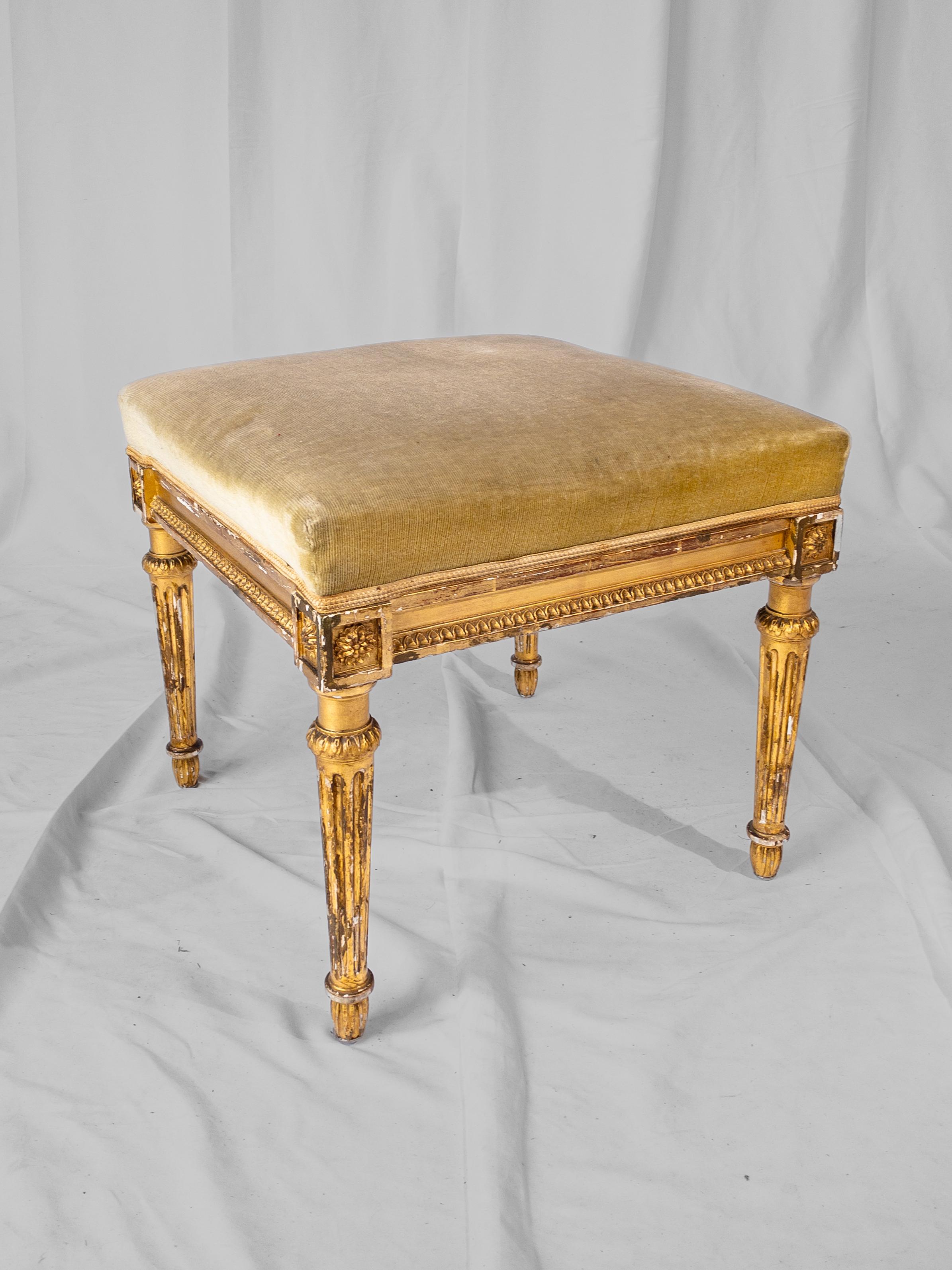 Exquisite and refined, this 19th-century French Louis XVI Style Gilt Stool epitomizes the elegance and sophistication of its era. Crafted with meticulous attention to detail, the stool features a lavish gold gilt frame adorned with delicate floral