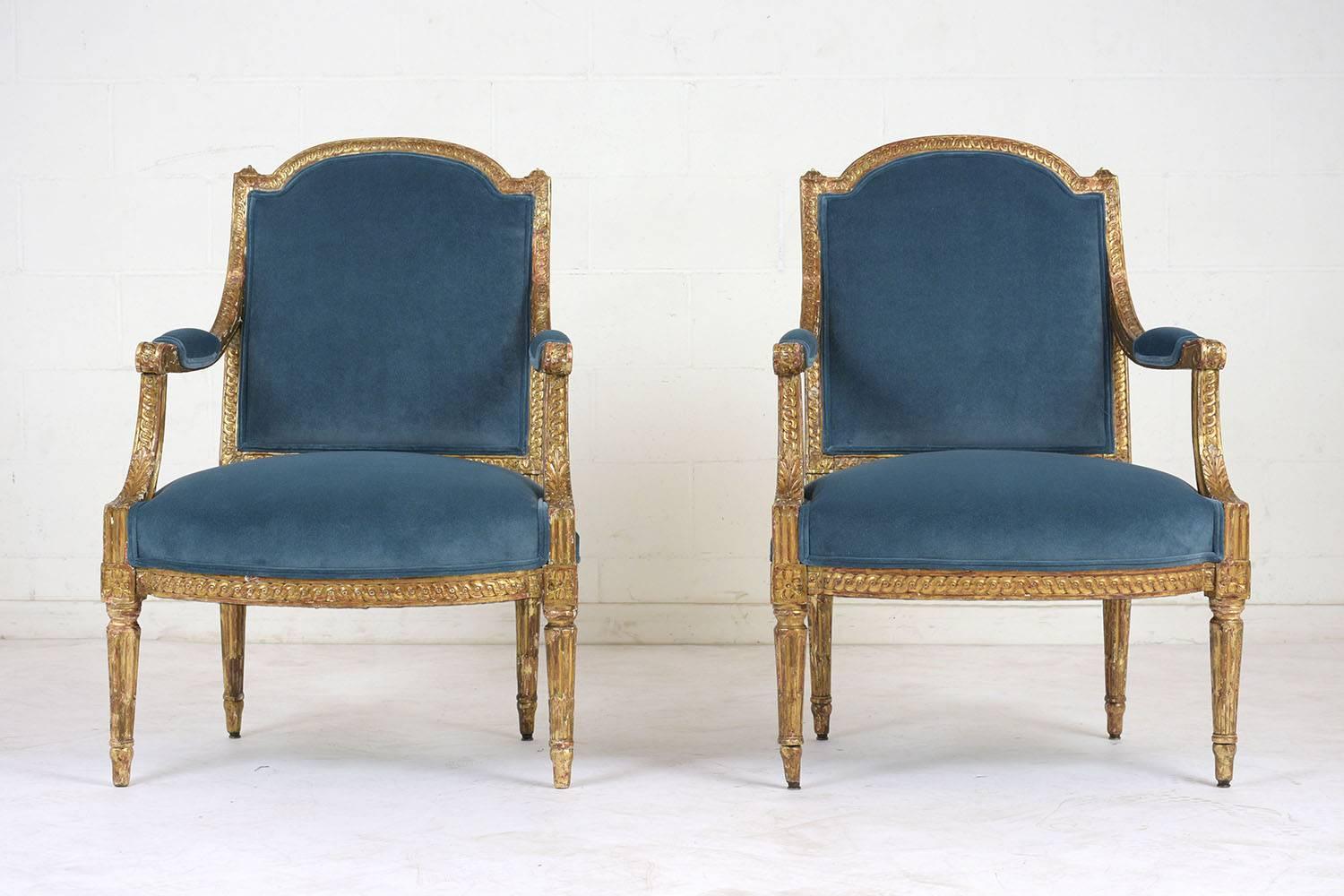 This pair of French Louis XVI style bergères dates to the 1860s. The carved frames are made of gilt wood with a beautiful distressed finish. The frames are adorned with decorative motifs, acanthus leaves, rosettes, and fluting. The seats have been