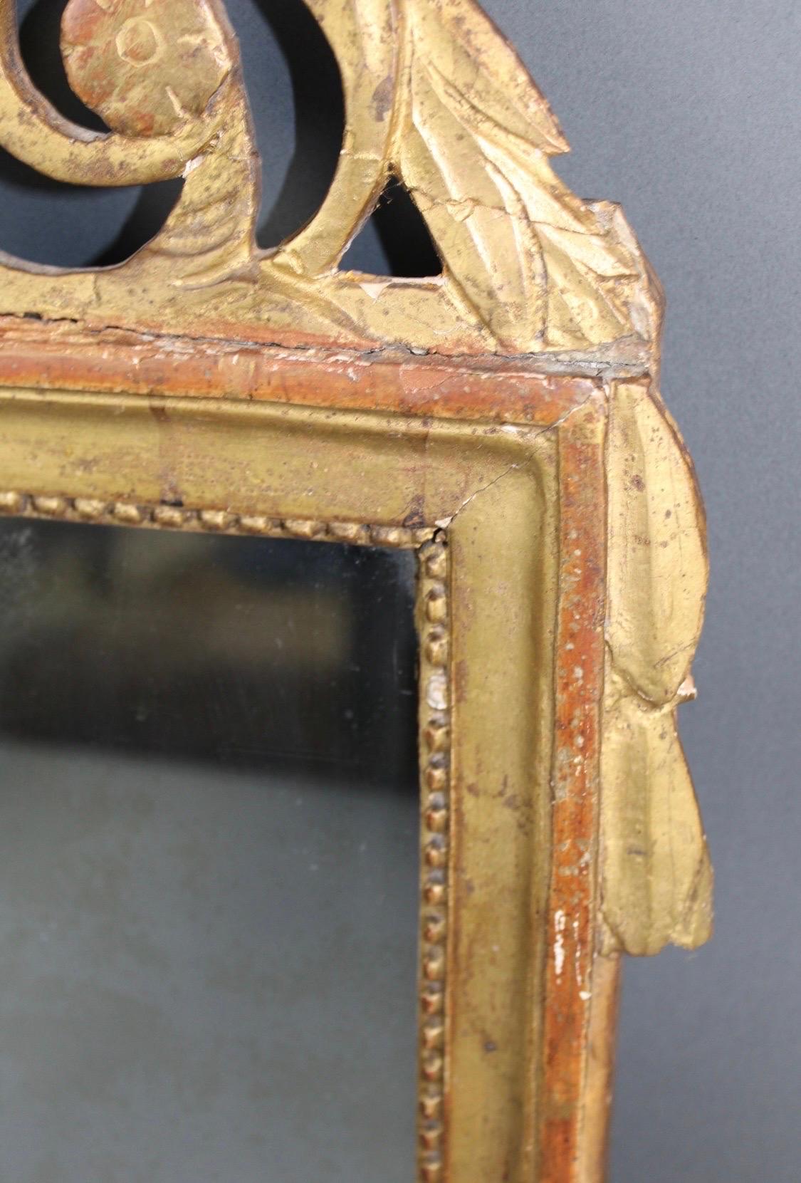 Sculpté à la main Miroir de style Louis XVI encadré de feuilles d'or, 19e siècle, avec écusson à thème musical en vente