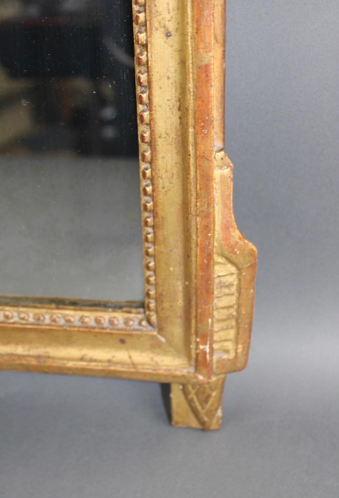 Miroir de style Louis XVI encadré de feuilles d'or, 19e siècle, avec écusson à thème musical Abîmé - En vente à Atlanta, GA
