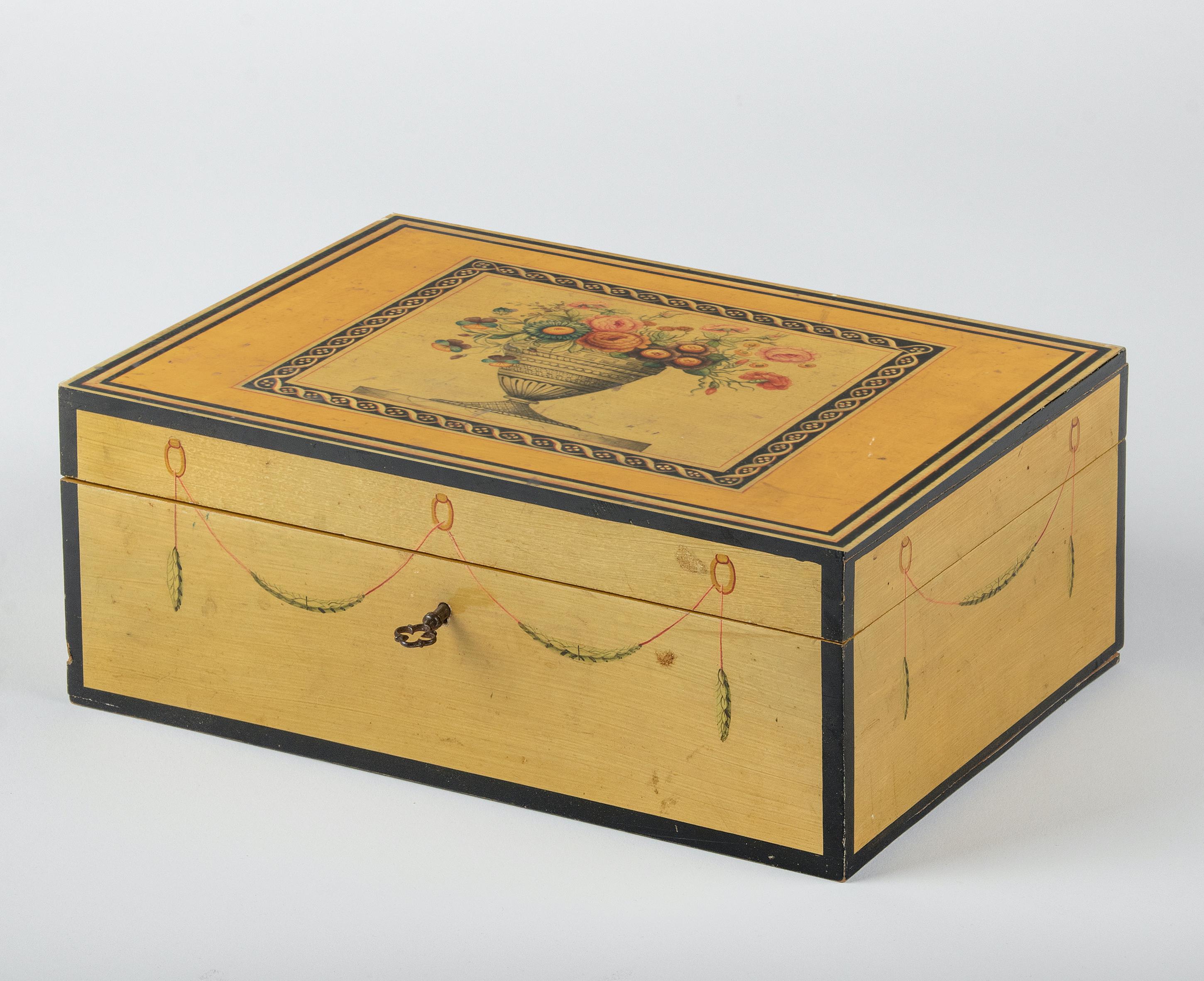Beautiful antique wooden box. The box is hand-painted in Louis XVI style with flowers and garlands. The painting is really refined with great color and detail. The interior is lined with a pink silk fabric. The box has a working lock and original