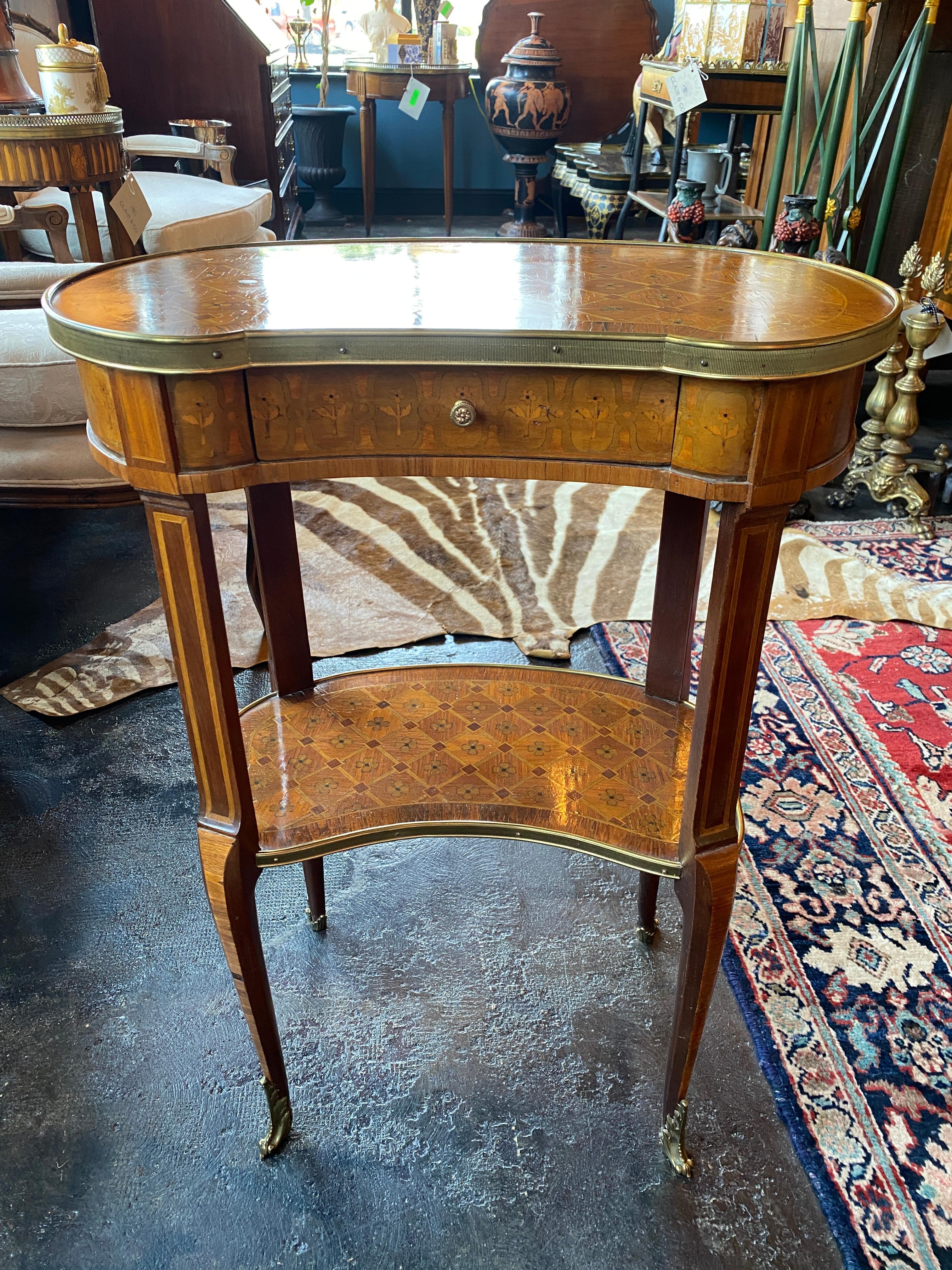 19th century French Louis XVI style kidney shaped side table with one drawer. Brass galleries and sabots. One brass pull in the center drawer. Parquetry inlaid surfaces on the top and lower shelf.