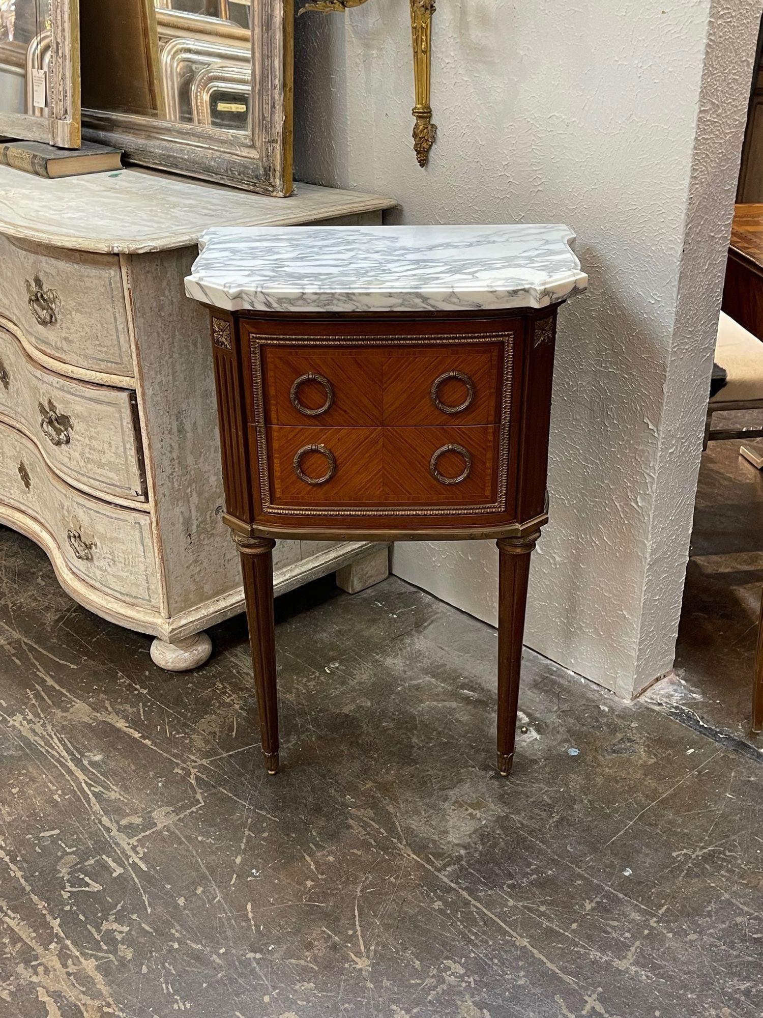 Handsome 19th century French Louis XVI style mahogany and bronze side table. The piece has very pretty hardware and a marble top. A great accent piece that adds an upscale look!