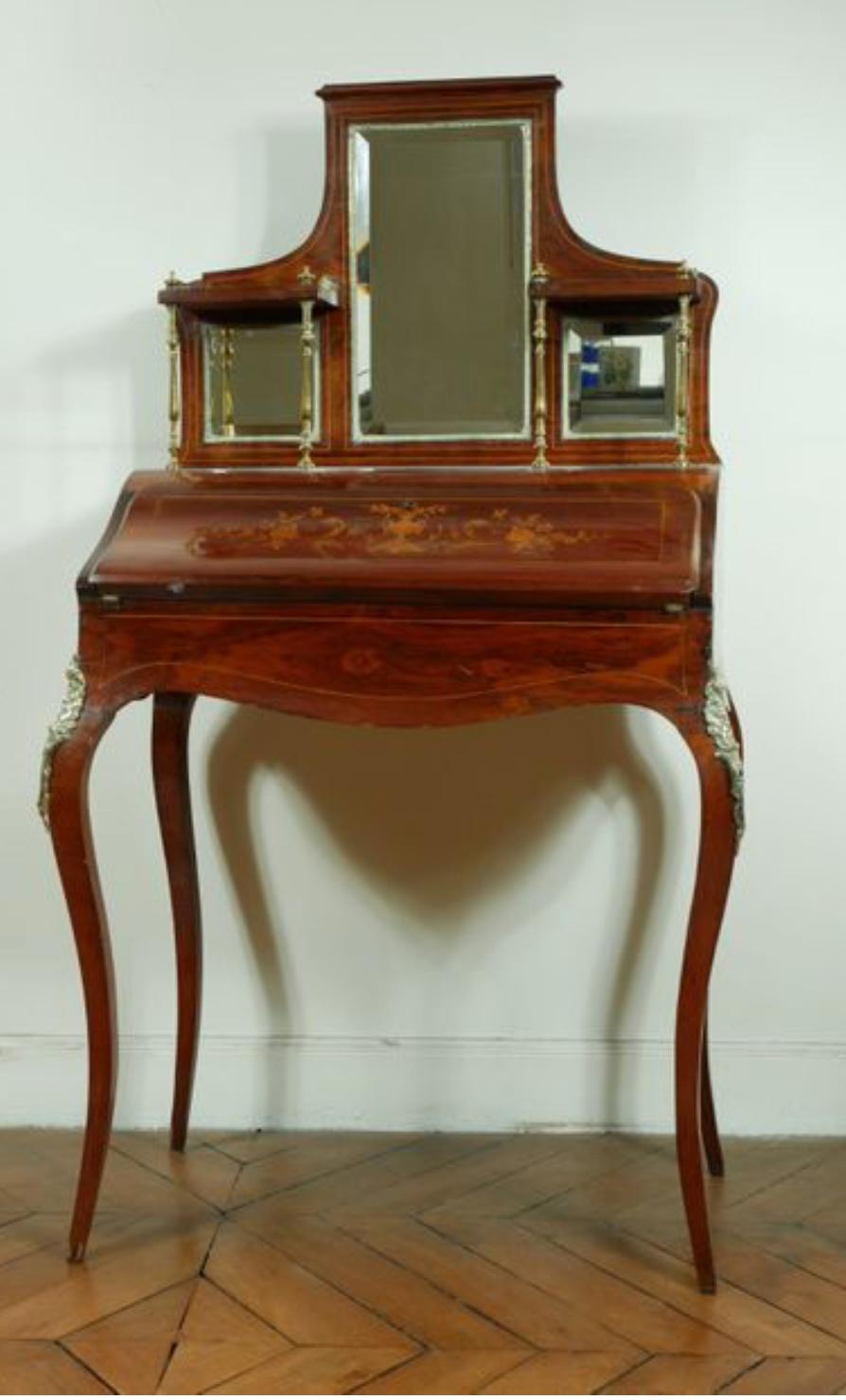 This is a beautiful antique mahogany inlaid Bonheur Du Jour, or Ladies writing desk, circa 1890 in date. The fall front opens to reveal an interior of leather writing surface, and bank of three drawers. The top has three mirrors with brass