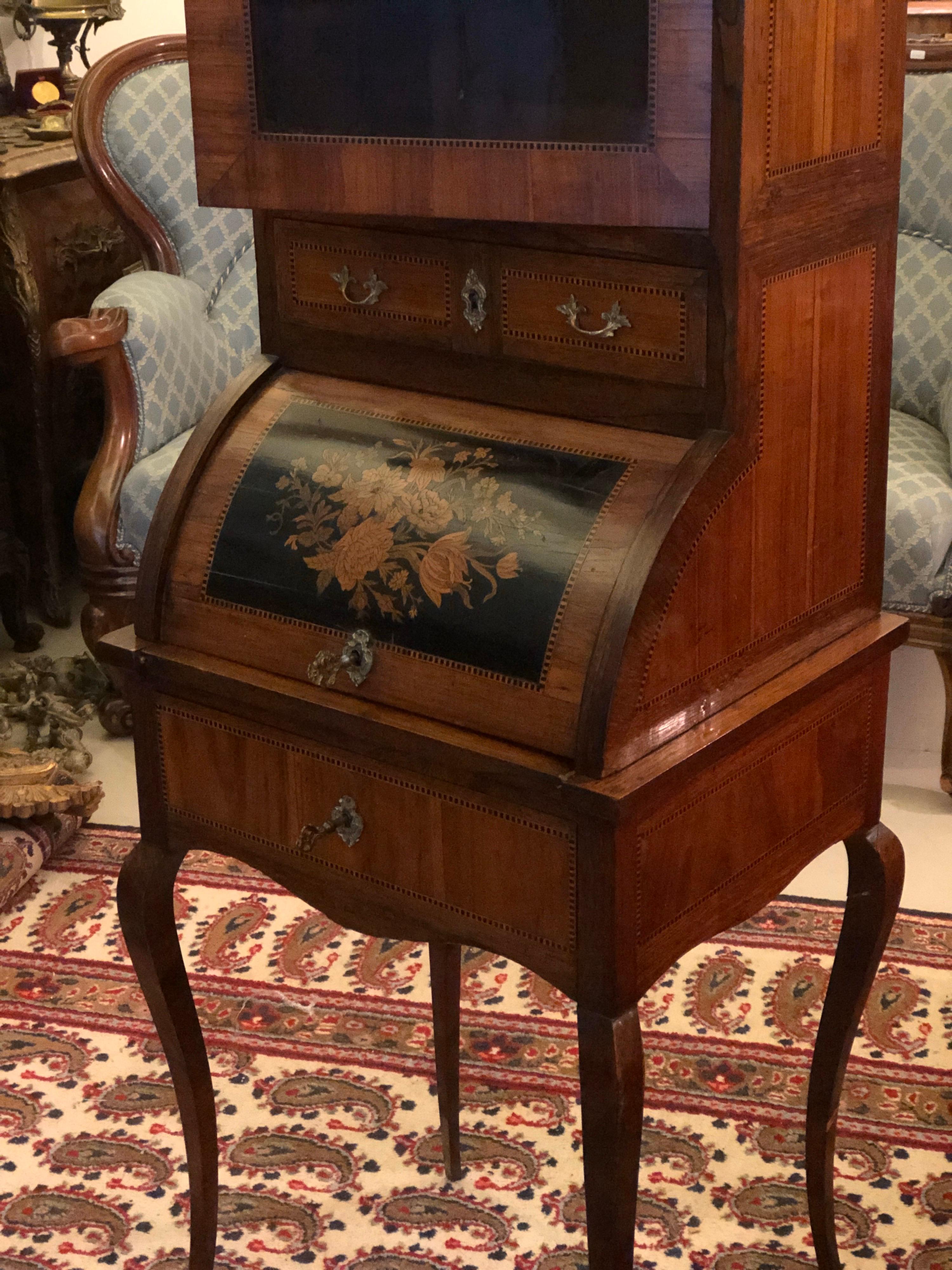 This is a beautiful French antique mahogany inlaid ladies writing desk, circa 1870 in date. The fall front opens to reveal an interior of writing surface, and bank of two drawers. The top has a vitrine with glass front door and white marble top. The