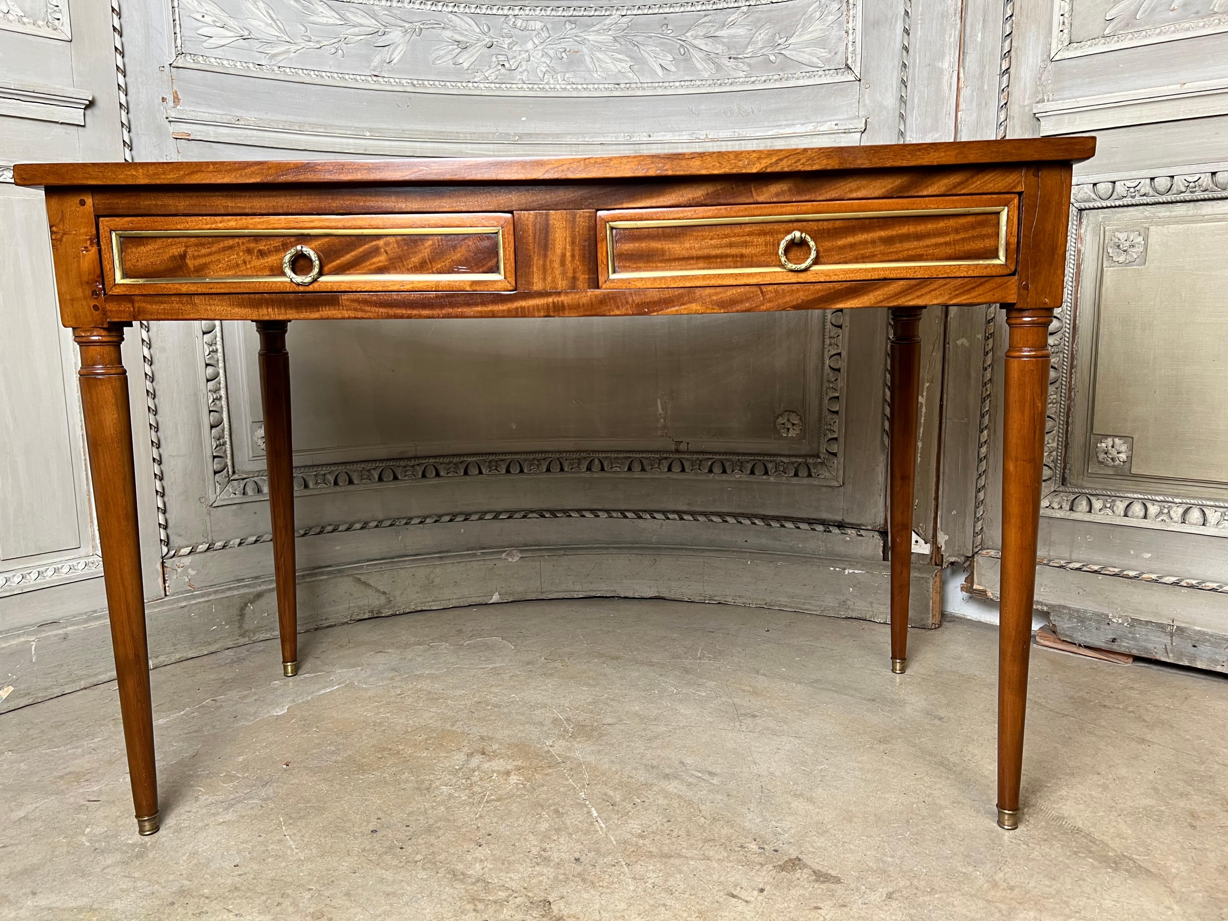 Tavolino da scrittura francese in stile Luigi XVI del XIX secolo con piano in pelle marrone lavorata e accessori in bronzo.  
Questo tavolo affascinante e versatile può essere utilizzato come tavolino, comodino o piccola scrivania.  È rifinito su