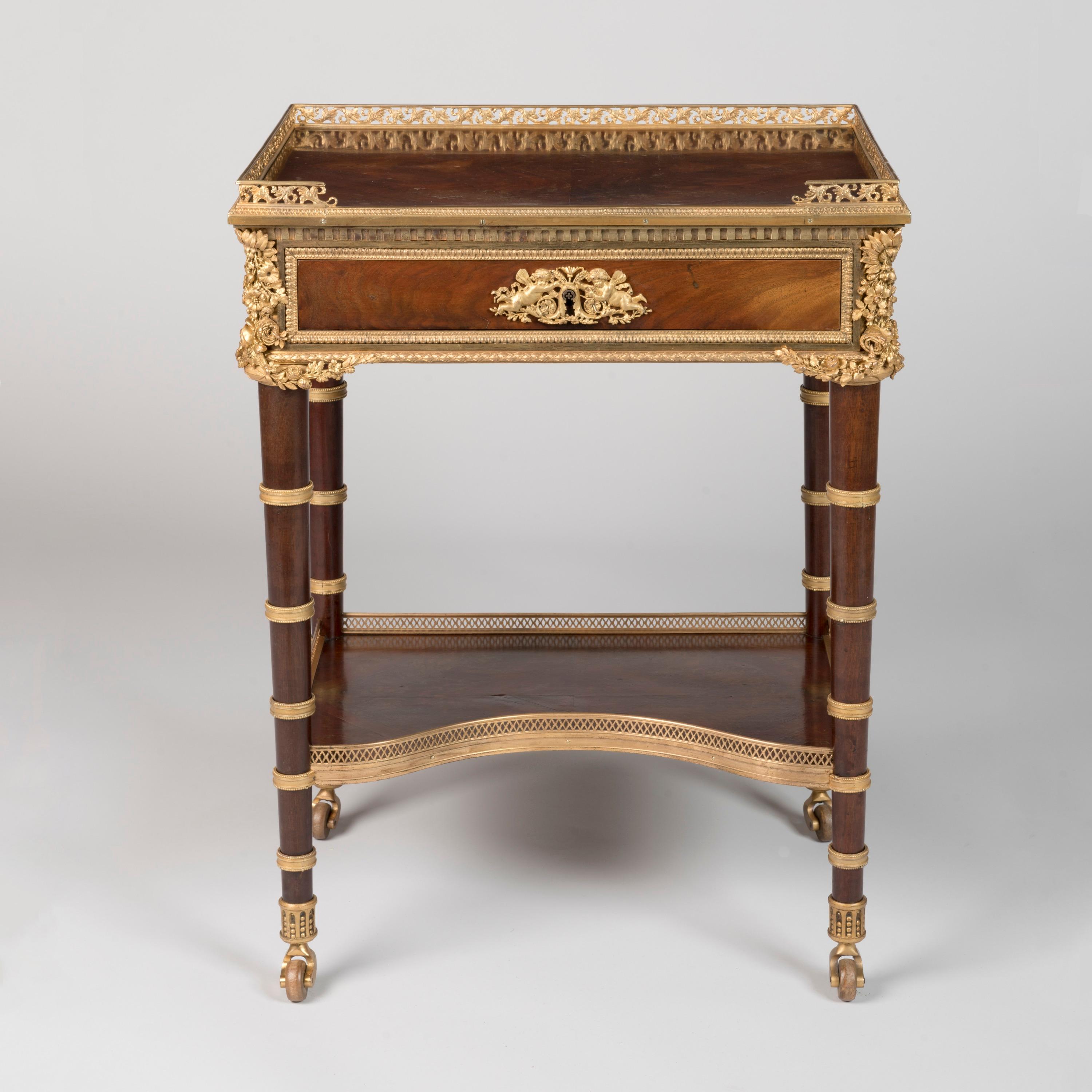Mesa auxiliar de estilo Luis XVI montada en ormolina

Según el original de Jean-Henri Riesener
Hoy en el Louvre

Construida en una llamativa caoba flameada que ha sido enchapada en cuarto para realzar su belleza, ampliamente aderezada con monturas