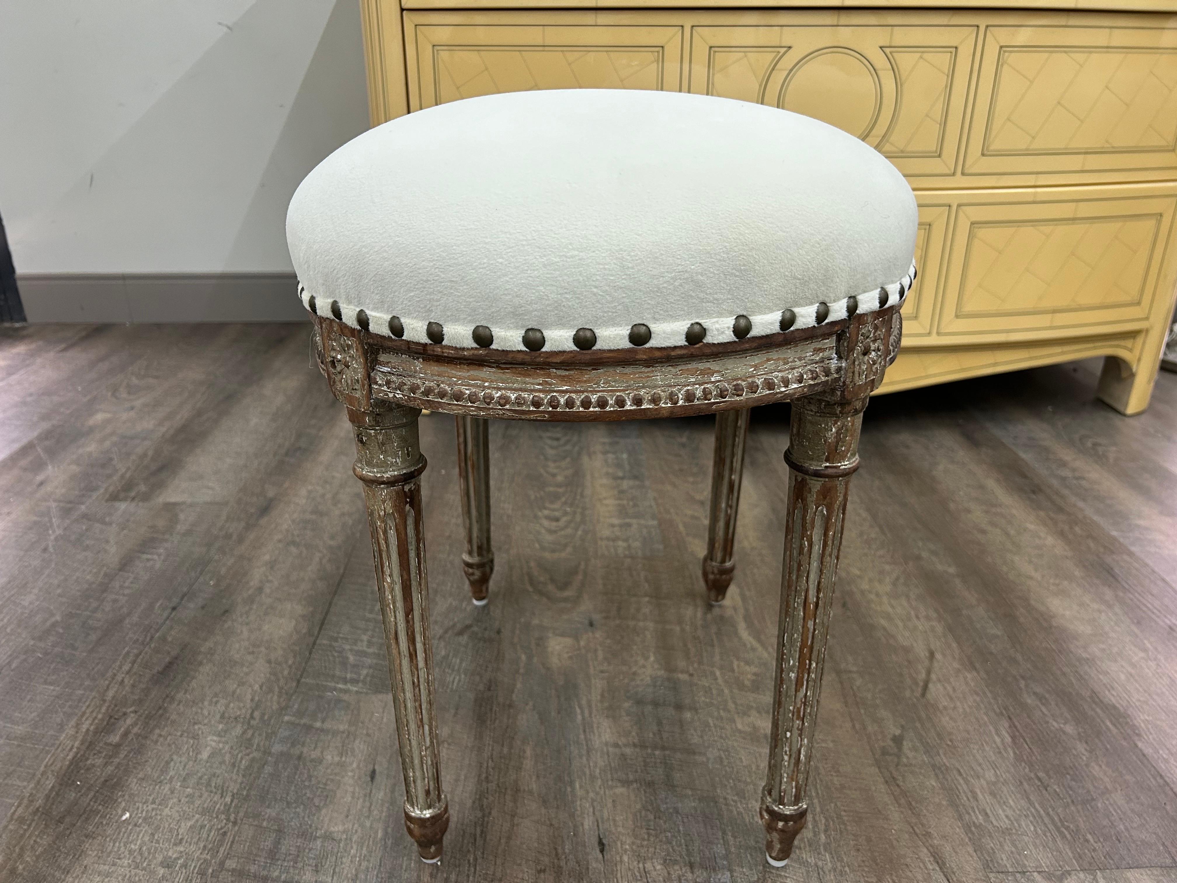 Otomana francesa del siglo XIX, estilo Luis XVI.
Esta preciosa otomana o puf ovalado de estilo francés antiguo tiene un bonito acabado pintado envejecido y se ha tapizado de nuevo en una tela de terciopelo color crema con detalles de clavos de latón