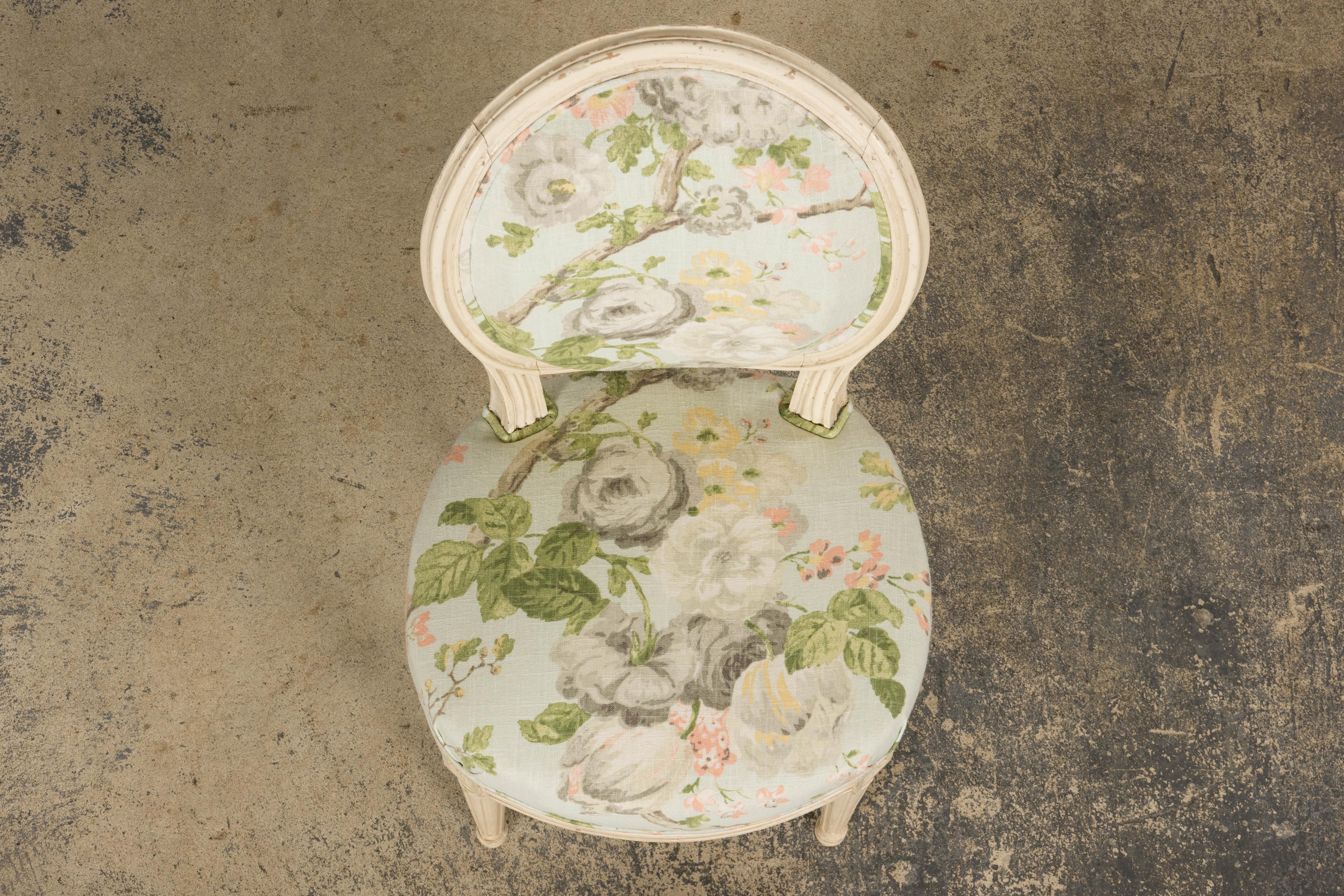 Una exquisita silla auxiliar pequeña de finales del siglo XIX, de estilo Luis XVI, procedente de la Provenza francesa. La estructura artesanal tiene un elegante respaldo ovalado y está acabada en un suave blanco crema con una pátina naturalmente