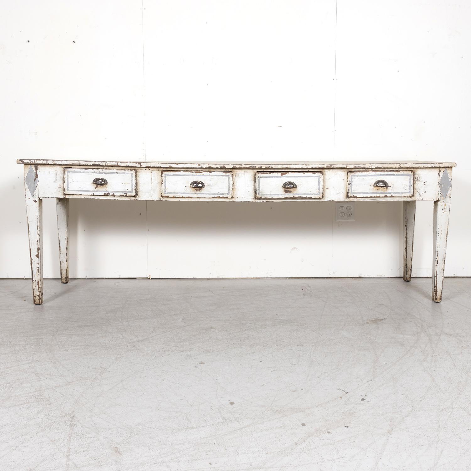 A fantastic large 19th century French Louis XVI style white painted console table with bluish gray accents, circa 1880s, having a rectangular top above an apron featuring four drawers with original bin pulls that offer great storage for daily use.