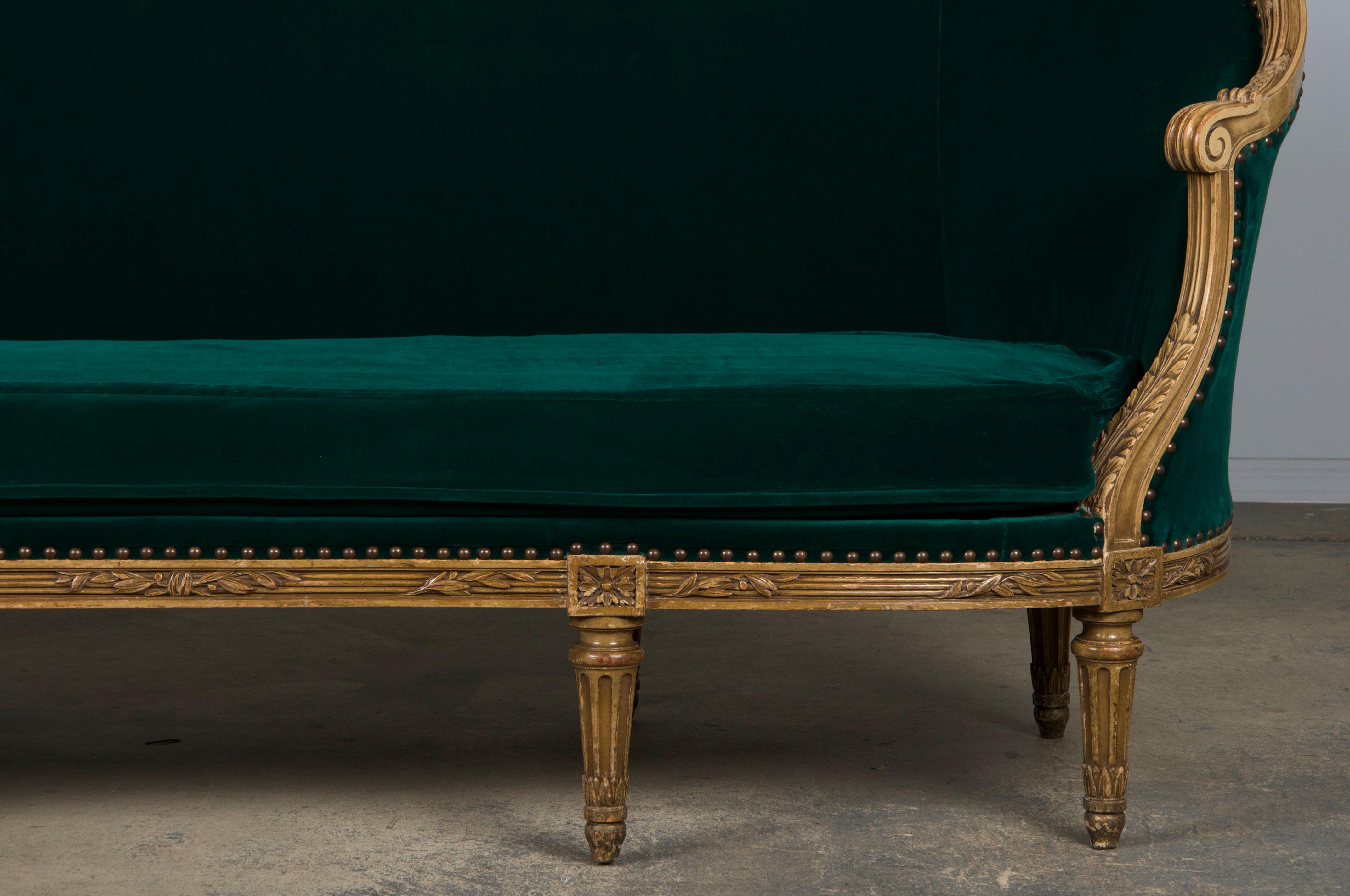 Uno squisito divano o canapè francese della fine del XIX secolo, realizzato in stile Luigi XVI e proveniente direttamente dalla Provenza, in Francia. Realizzato a mano in legno massiccio, il divano presenta un'elegante struttura posteriore curva,