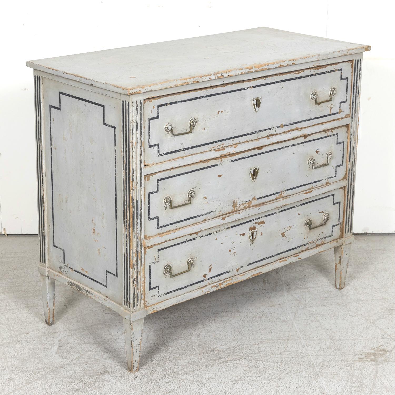 A handsome 19th century French Louis XVI style painted wooden commode or chest of drawers handcrafted in Provence, having a wonderfully distressed blue gray painted finish with dark charcoal accents, circa 1890s. A rectangular top sits above a case