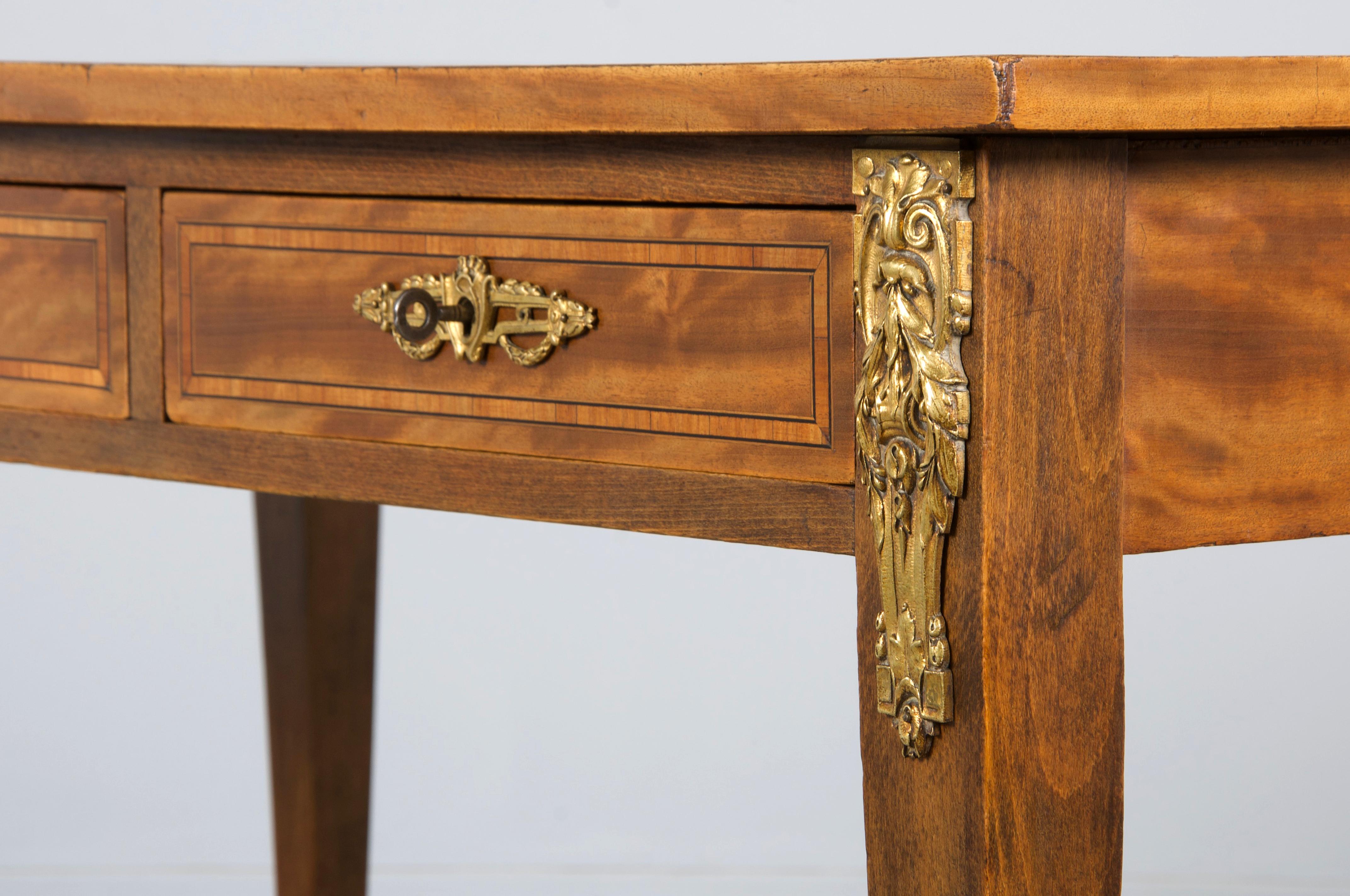 Un elegante scrittoio francese della fine del XIX secolo in stile Luigi XVI, proveniente dalla Provenza. Sapientemente realizzato a mano in legno di raso, presenta un piano rettangolare rivestito in vinile verde scuro, che mostra una patina