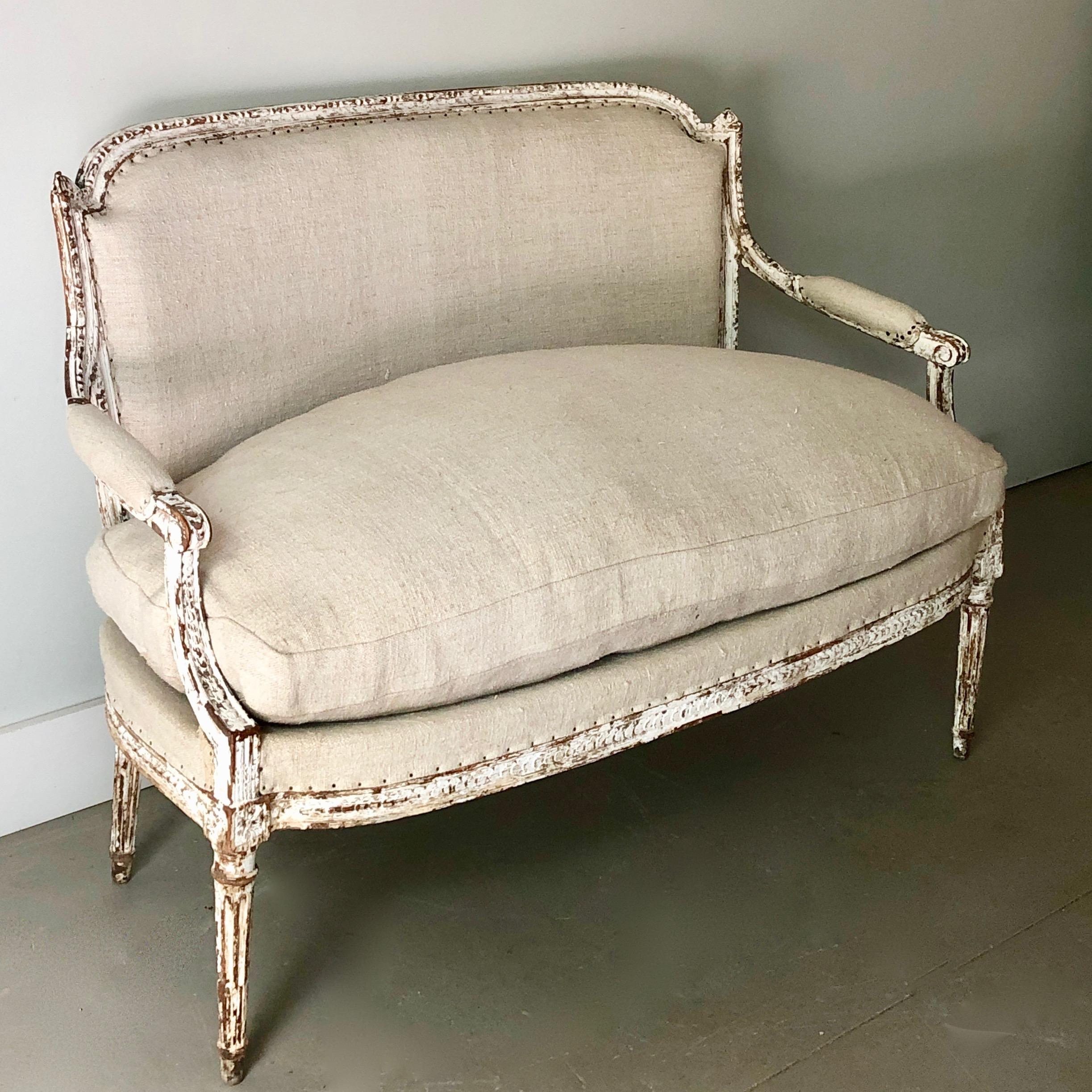19th century small, charming French Louis XVI style settee with elegant carved details on shaped back rail, knees and aprons and very soft 