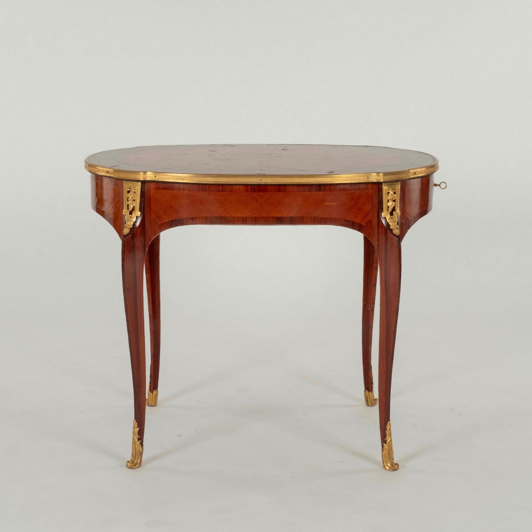 Esta mesa francesa del siglo XIX, de estilo Luis XVI, personifica la elegancia intemporal y la refinada artesanía característica de incluir ornamentadas monturas de bronce ormolu, intrincado trabajo de marquetería, con motivos geométricos