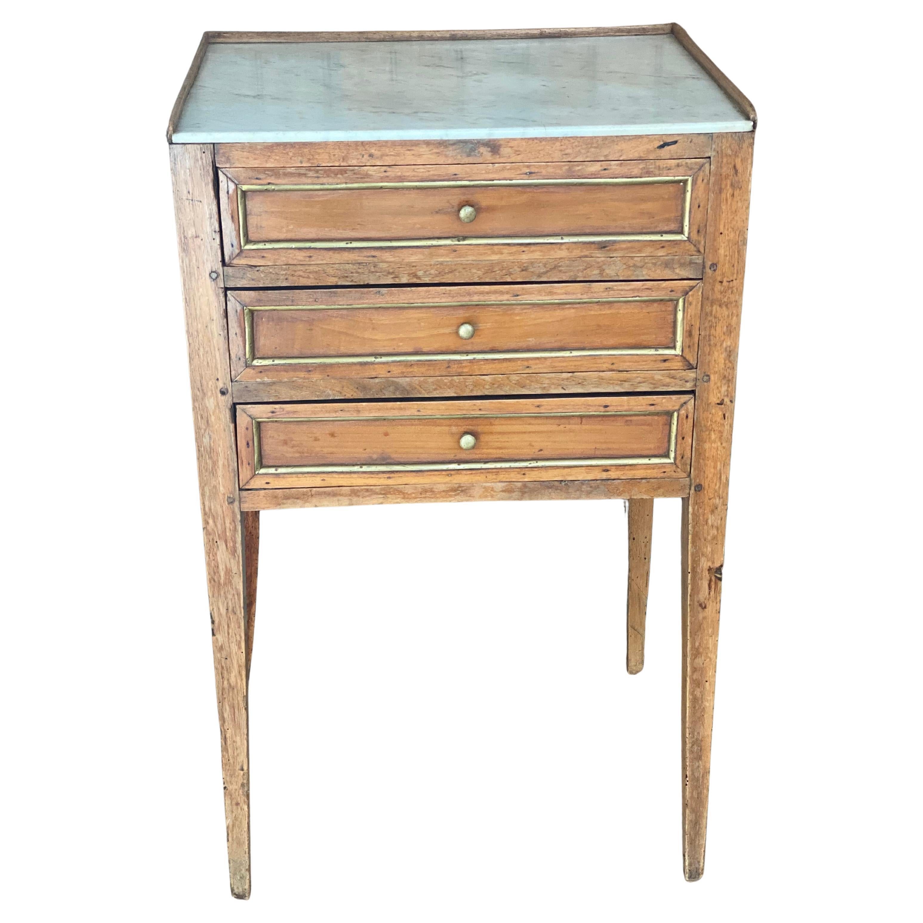  Table de nuit française du 19ème siècle de style Louis XVI à trois tiroirs avec plateau en marbre
Voici une charmante table de nuit en marbre de style Louis XVI, datant du 19e siècle. Fabriqué principalement en bois de cerisier, il présente une