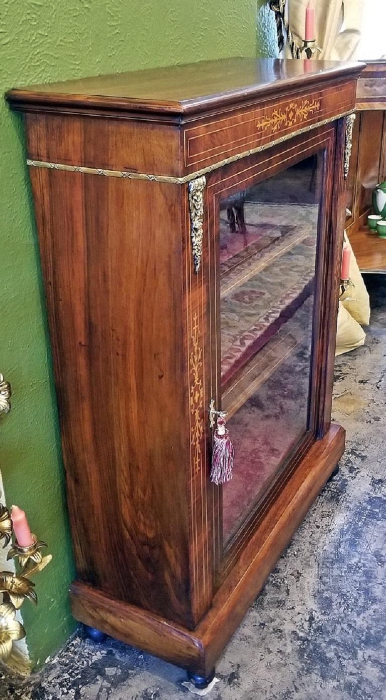 Lovely Louis XVI style glass and walnut vitrine or display case of neat proportions.

Beautiful ormolu mounts and trim. Burl and butterflied walnut.

Single door with satinwood stringing, three display shelves and re-finished with a luxurious