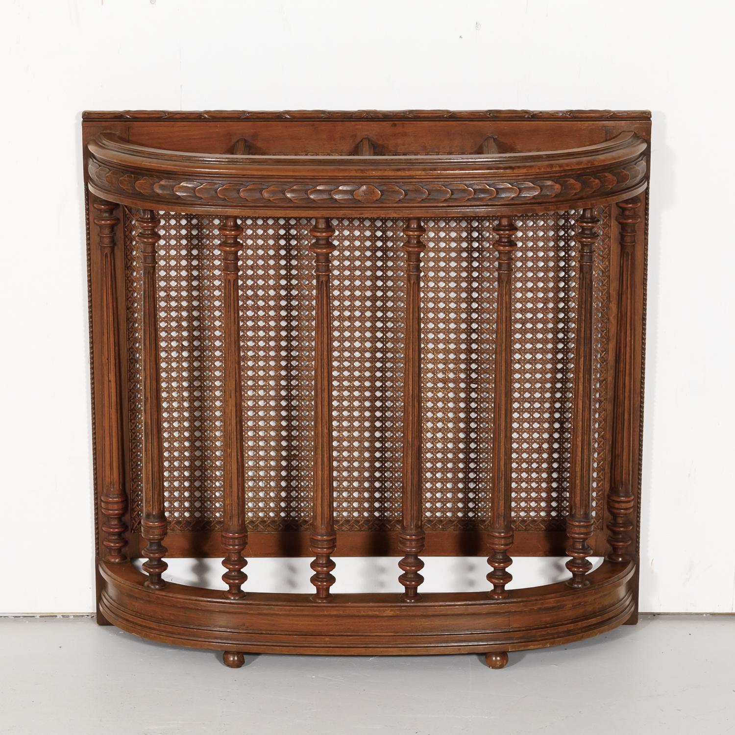 Handsome 19th century Porte-parapluie or umbrella stand handcrafted in Lyon of walnut with a cane back featuring typical neoclassical elements, circa 1890s. Made to stand against a wall, this umbrella stand is perfect for a small entry hall or mud