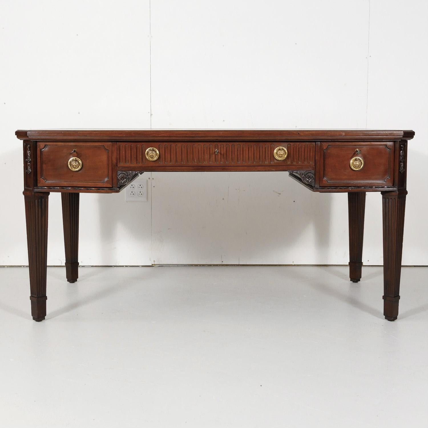 A fine 19th century French Louis XVI style bureau plat handcrafted of solid walnut by talented artisans in Lyon for the wealthy owner of a Maison de maître, having gilt bronze pulls and the original black tooled leather writing surface, circa 1850s.