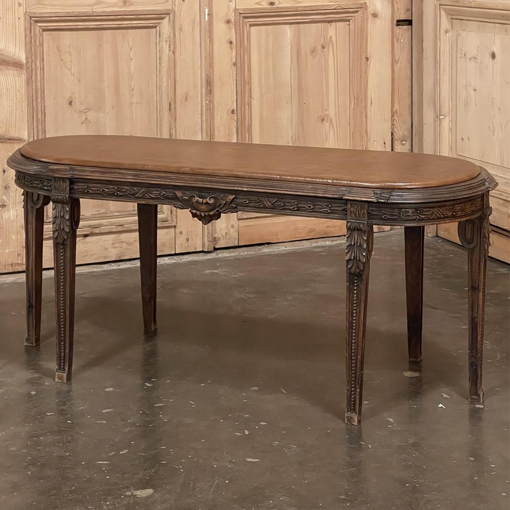 19th Century French Louis XVI upholstered bench features an unusual six legs with rounded ends making it much more ergonomic and sturdy than its contemporaries! Hand-crafted from solid fruitwood, it features carved sculpture all around the apron and