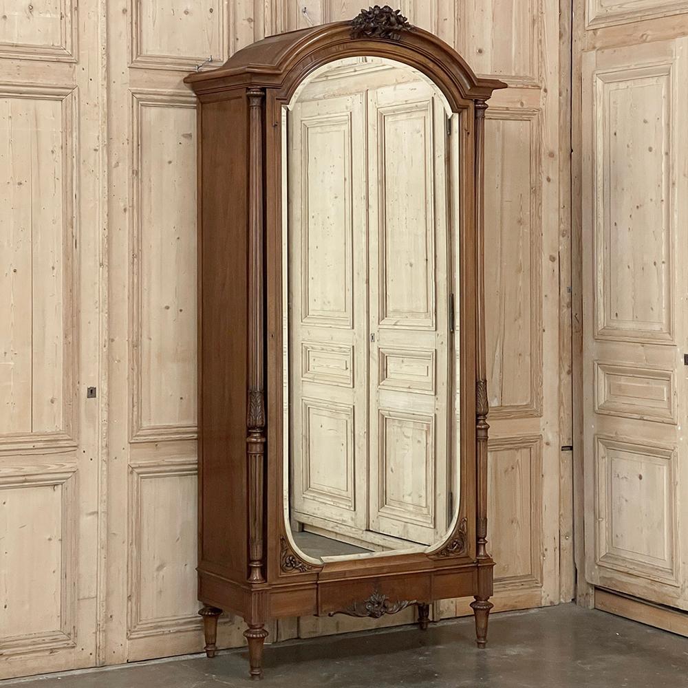 19th Century French Louis XVI Walnut Armoire ~ Wardrobe represents the epitome of understated neoclassical elegance!  Meticulously hand-crafted from sumptuous French walnut by master craftsmen, the design features a boldly arched crown centered with