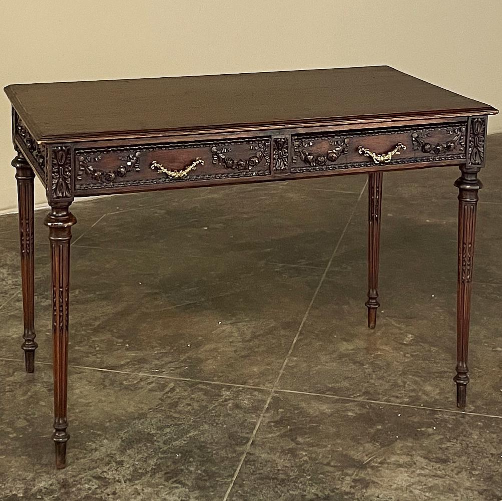 Cette table d'écriture Louis XVI du 19ème siècle en noyer à double face sera le complément parfait de toute pièce bien aménagée !  Idéale comme table d'appoint, table centrale ou table de bibliothèque, elle a été artistiquement sculptée avec des