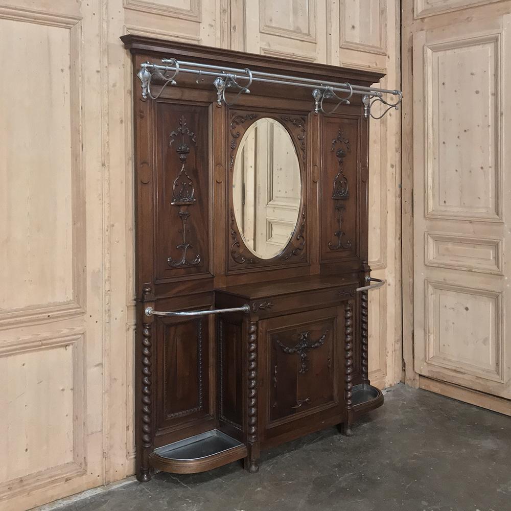 19th century French Louis XVI walnut hall tree is a marvel of craftsmanship, and remains in impeccable condition after over 100 years of faithful service by the front entrance to a lavish country home in northern France. Oval beveled mirror is