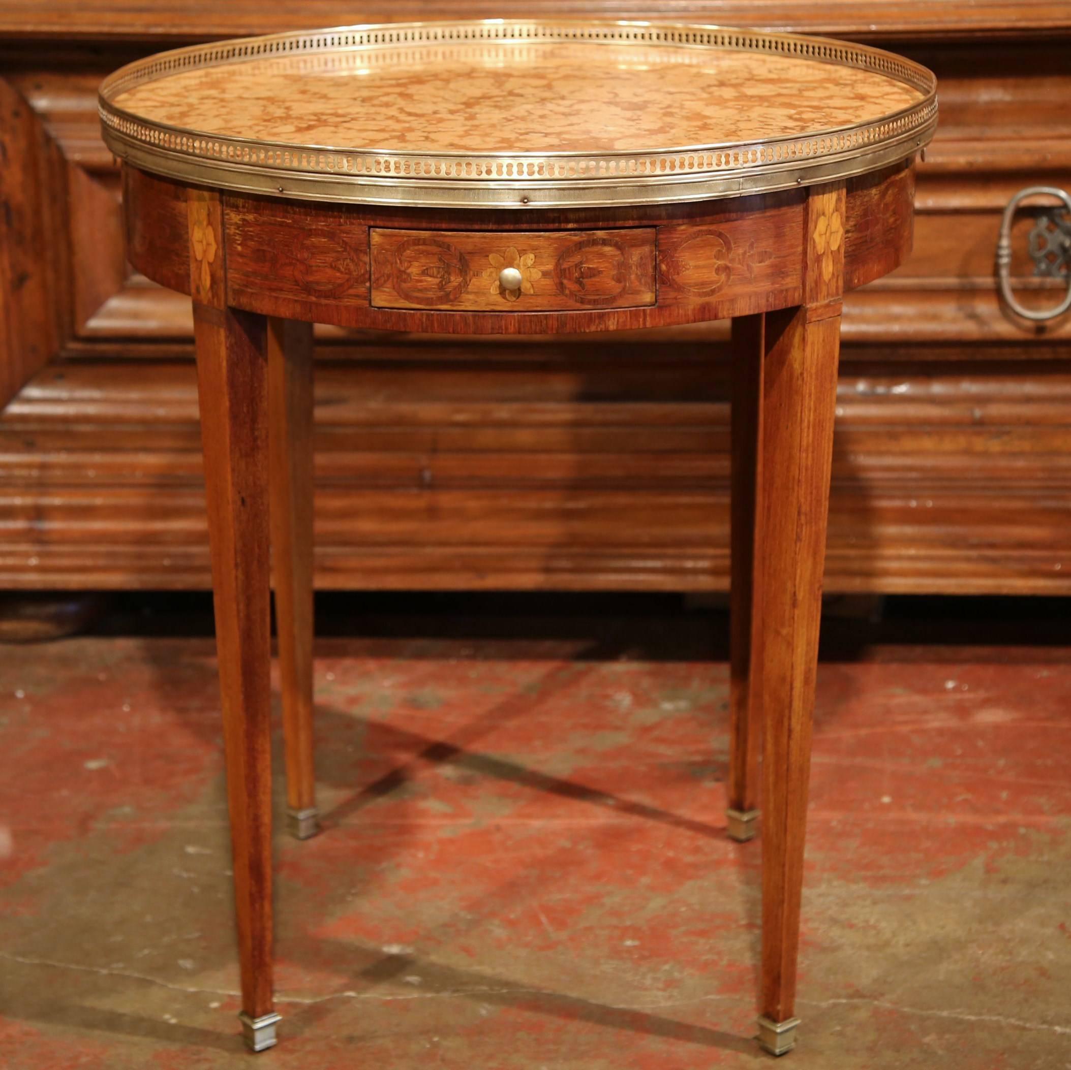 Use this elegant, antique fruit wood table as an occasional side table in a living room, crafted in France, circa 1890, the inlay table bouillotte features detailed marquetry work around the apron embellished with a pair of frieze drawers and two