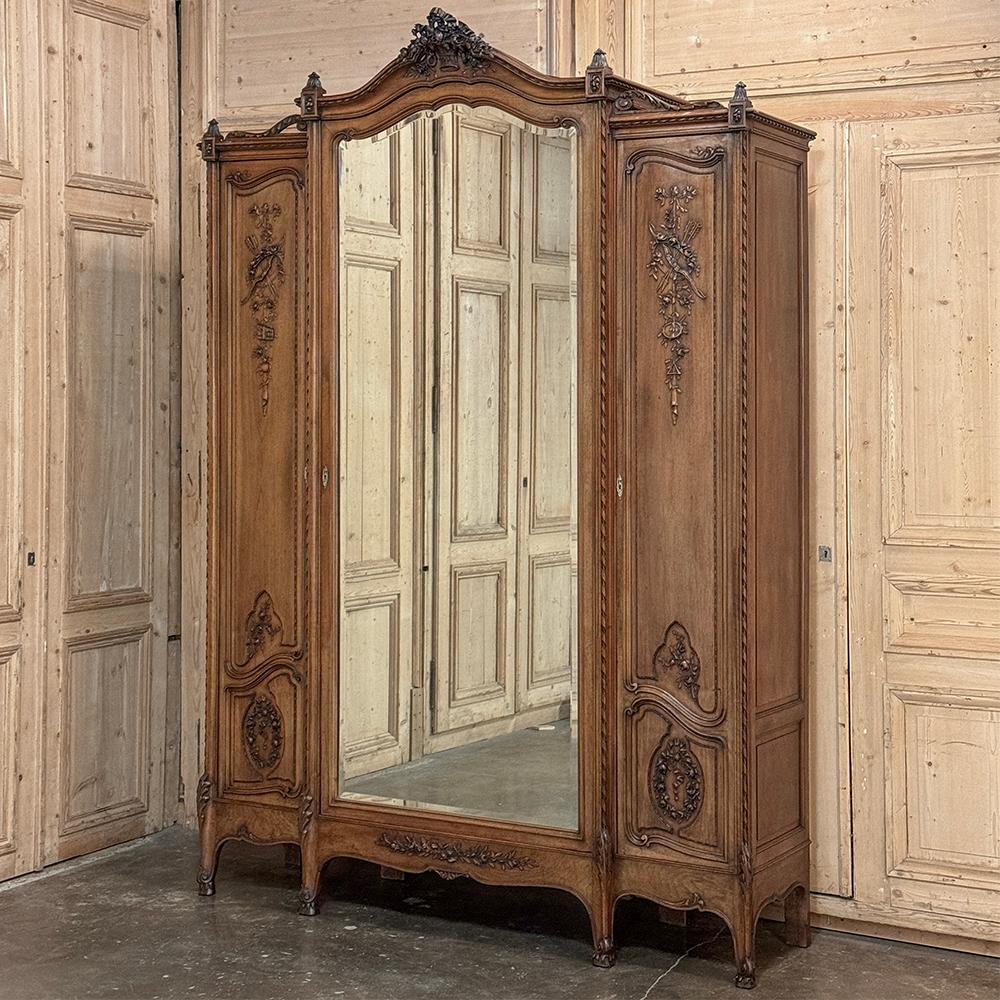 19. Jahrhundert Französisch Louis XVI Nussbaum Triple Armoire ist ein großartiges Beispiel für die hervorragende Handwerkskunst der Parisienne Tischler aus einer vergangenen Epoche!  Das aus ausgesuchtem französischem Nussbaumholz handgefertigte