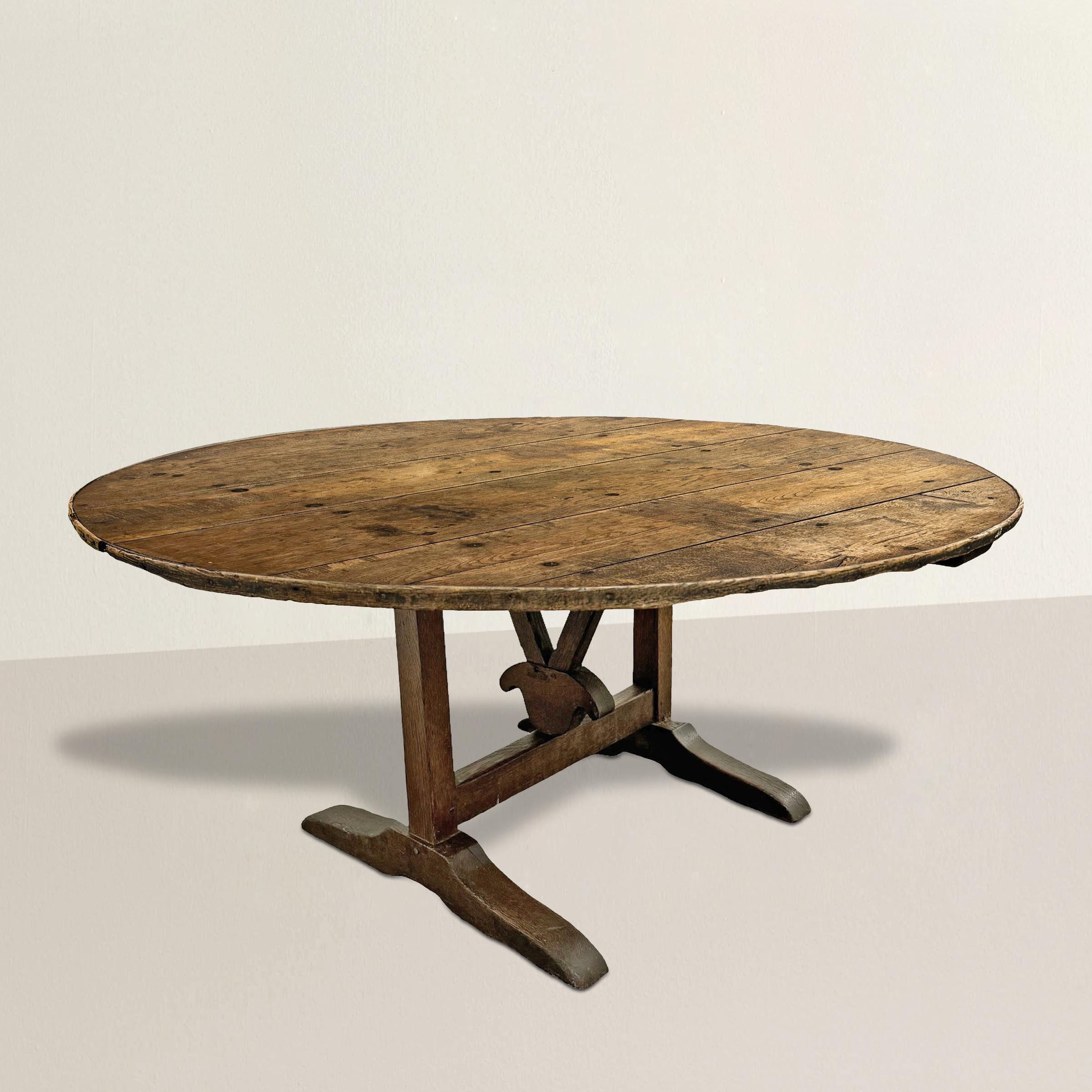 This 19th-century French oak vintner's table carries with it a rich history of winemaking tradition. Originally used in a vineyard for tasting wines, this table has been repurposed and transformed into a functional and versatile piece for modern