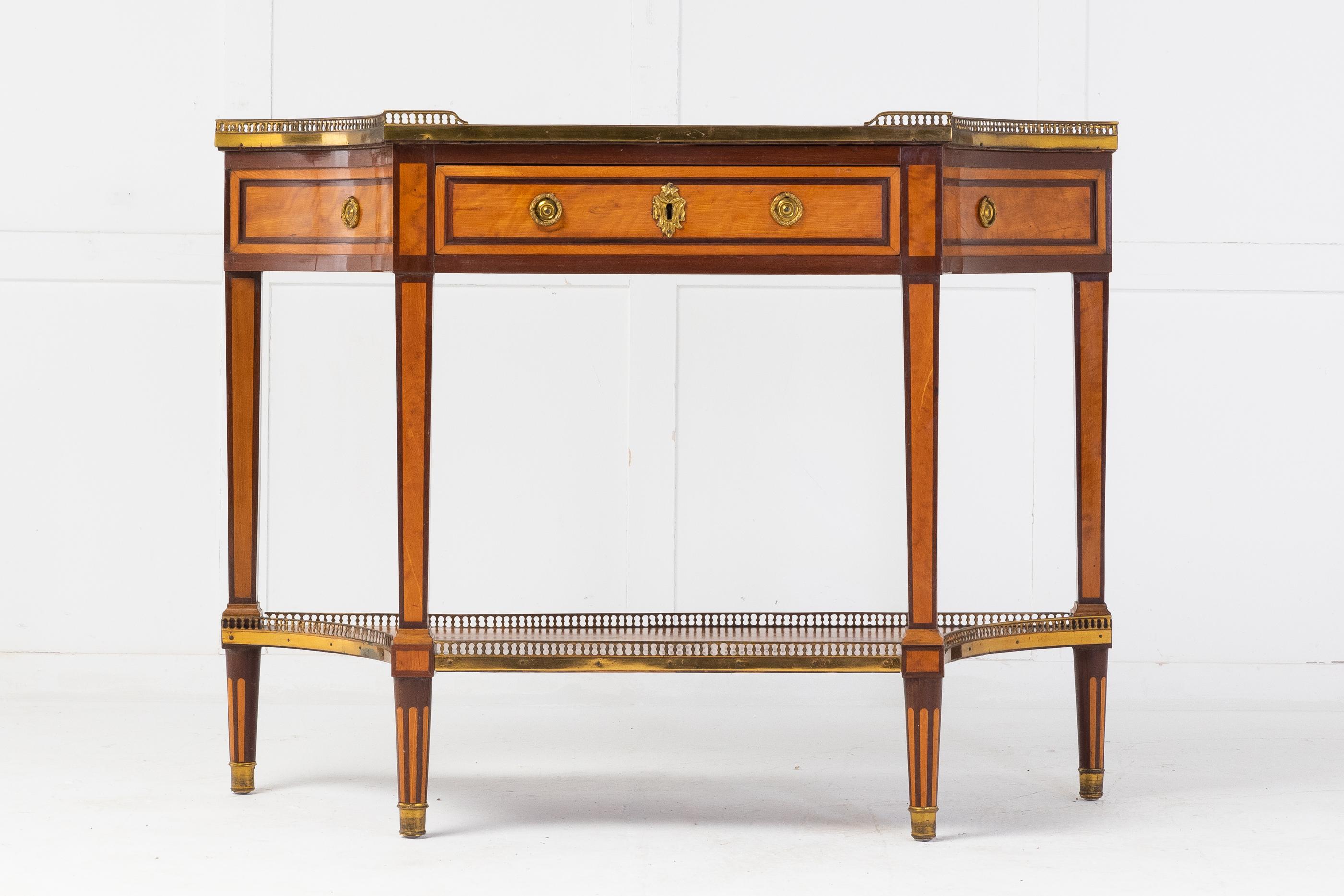 19th century French mahogany and satinwood console table with marble top and brass gallery. Having concave-sided rectangular top with an inset white marble. With a three-quarter pierced gallery, above a panelled frieze drawer with edge banding and