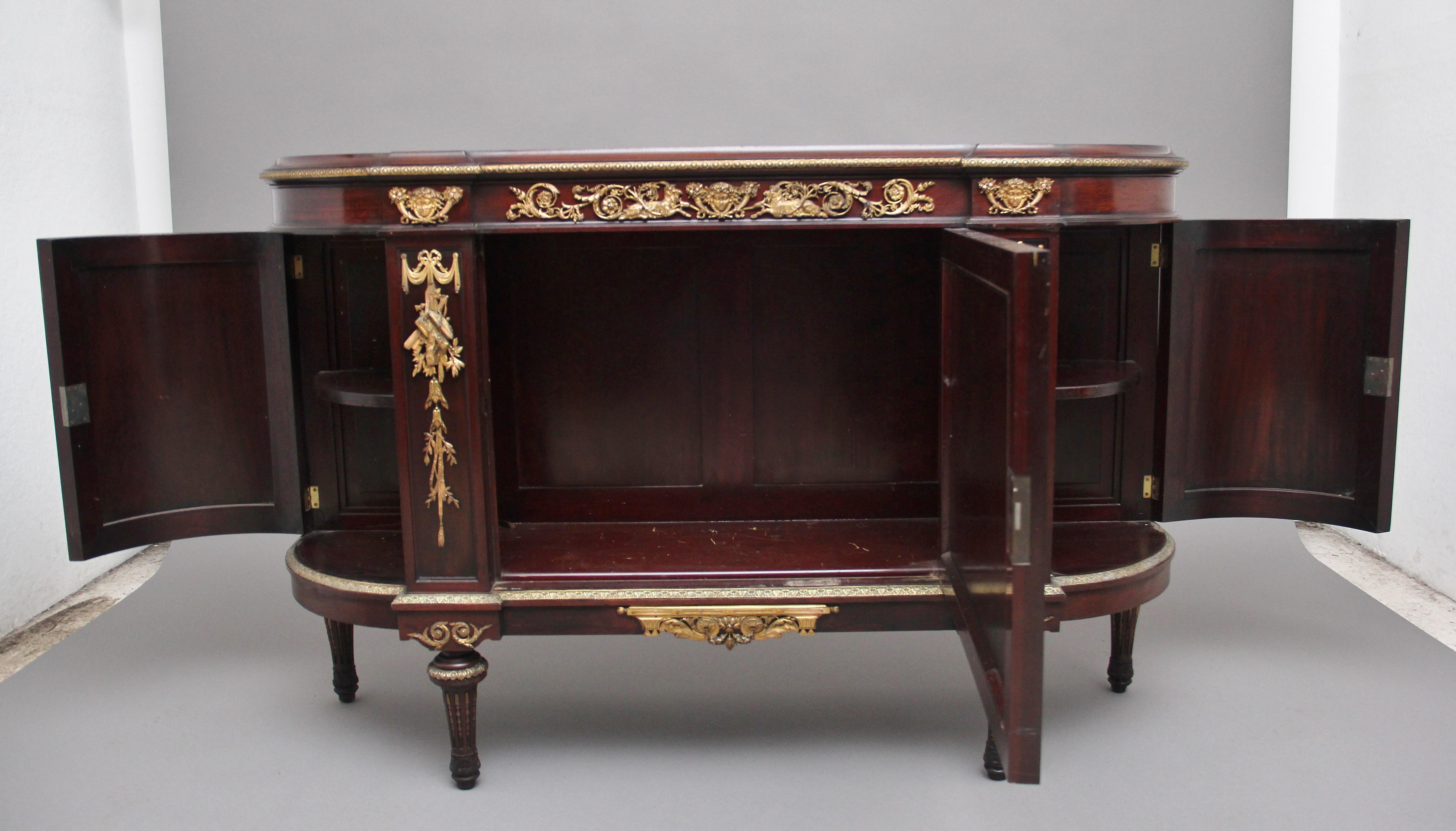 19th century French mahogany cabinet, the shaped and moulded edge top having ormolu beading running underneath, the frieze decorated with decorative ormolu mounts, a cupboard below with the door having a painted panel depicting a French countryside