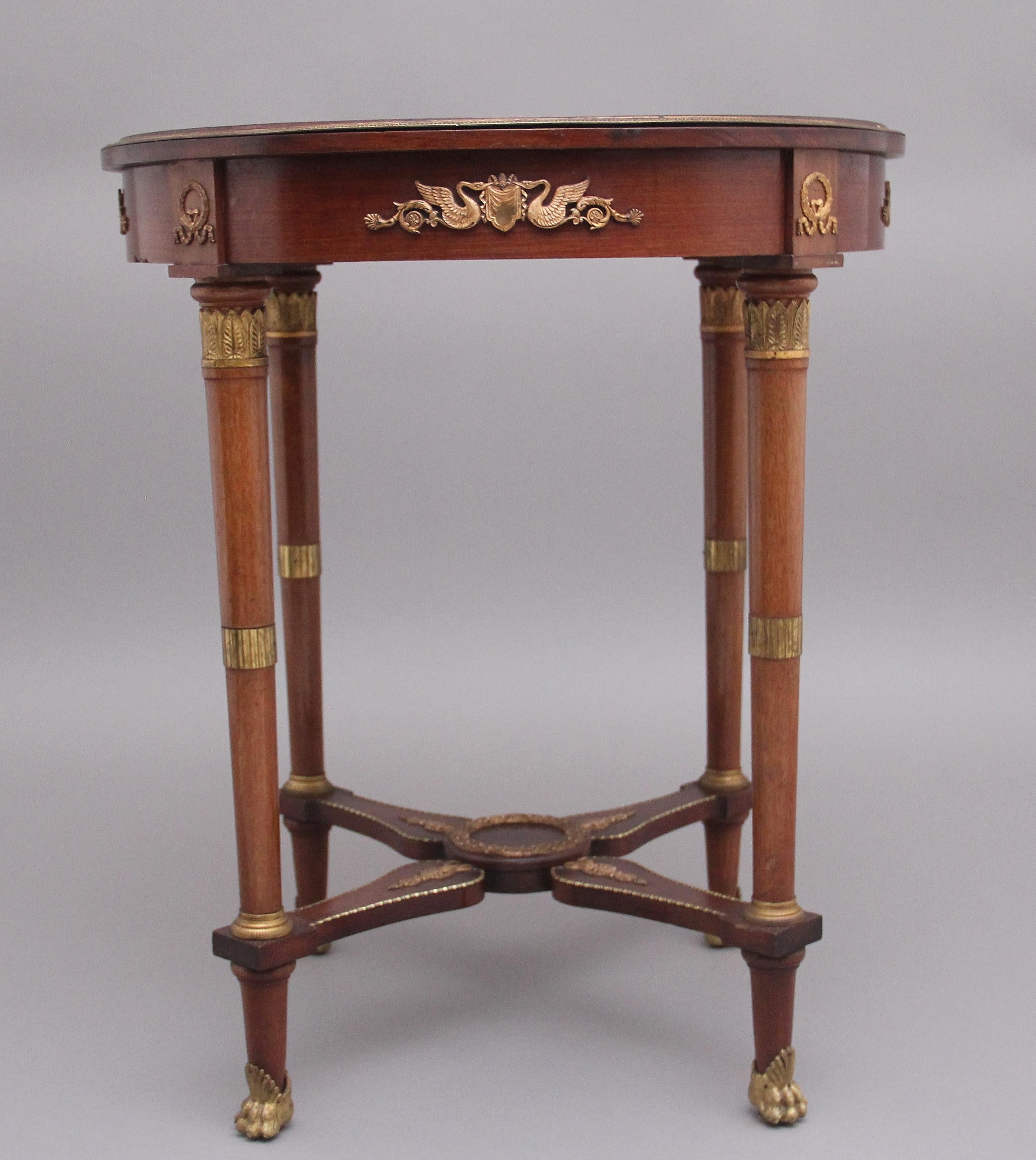 19th Century French mahogany centre table in the Empire style, having a wonderful decorative segmented top with engraved brass moulding, the frieze below having brass mounts along each section, supported on turned and tapered legs with further brass