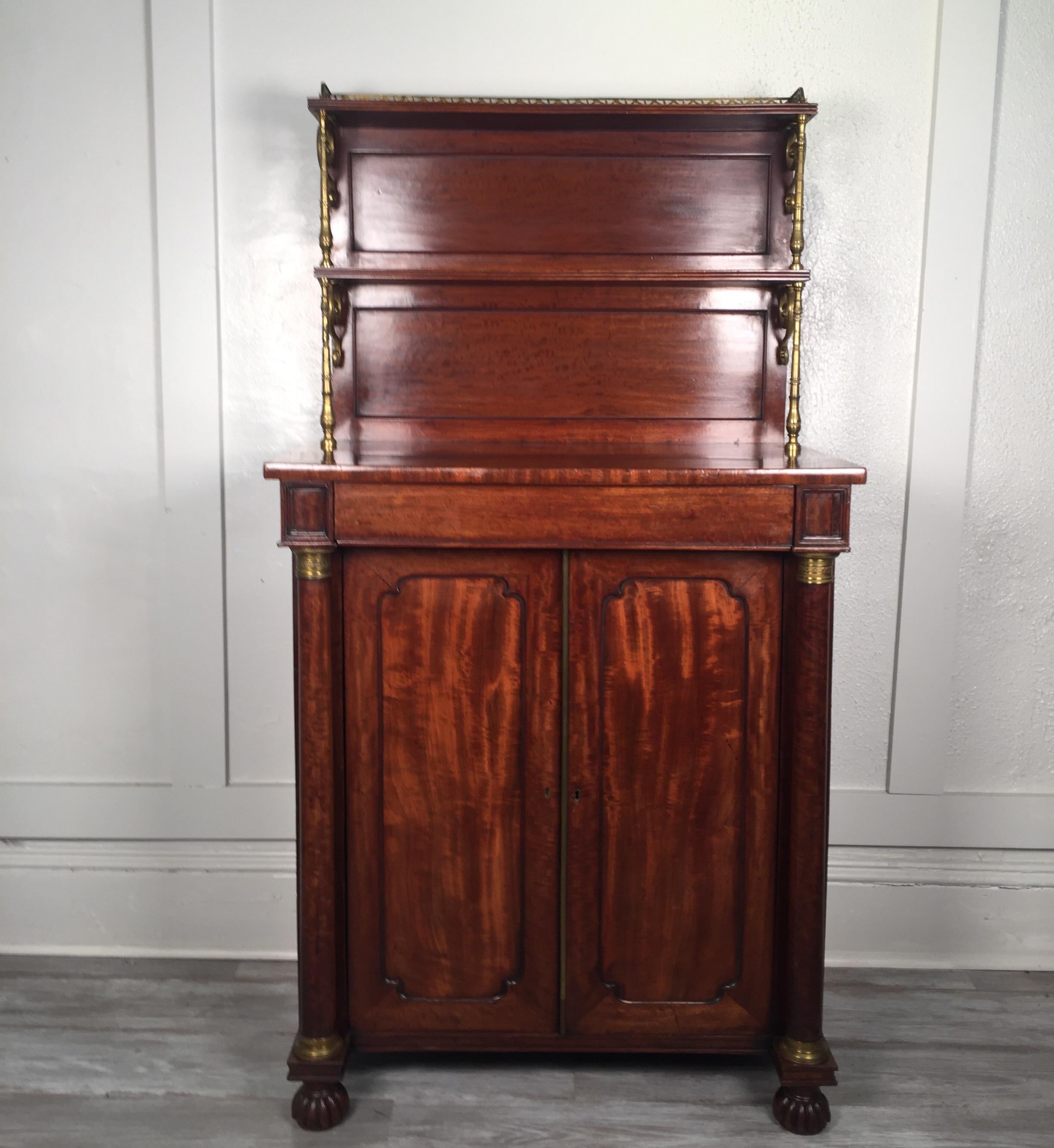 Lovely French mahogany and brass Empire style chiffoniere server A diminutive size with upper open shelves and closed storage at the bottom.The wood in a highly figurative flame mahogany...